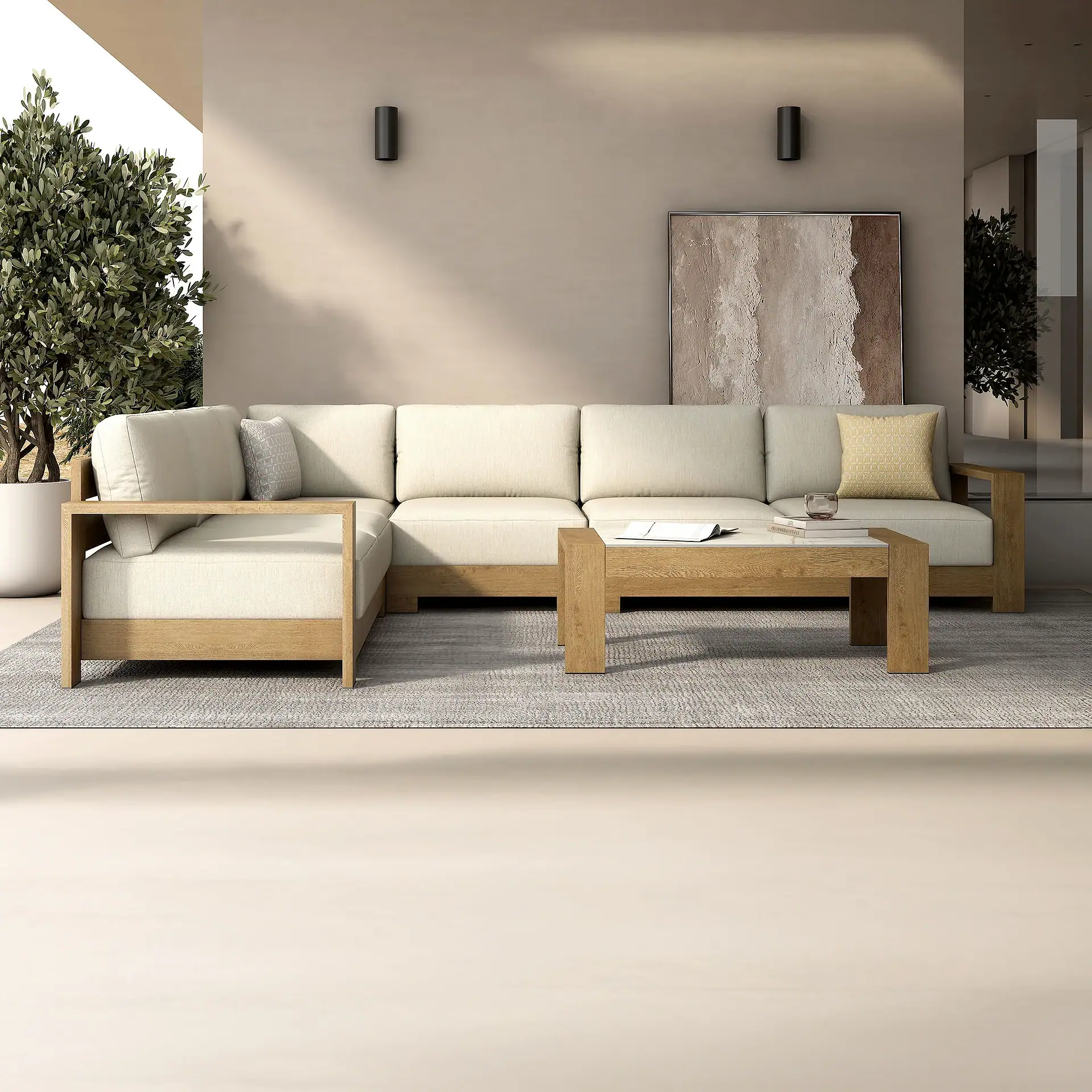 A modern outdoor living area with an L-shaped wooden sectional sofa, light cushions, a coffee table with books and a drink, and abstract art on a beige wall.