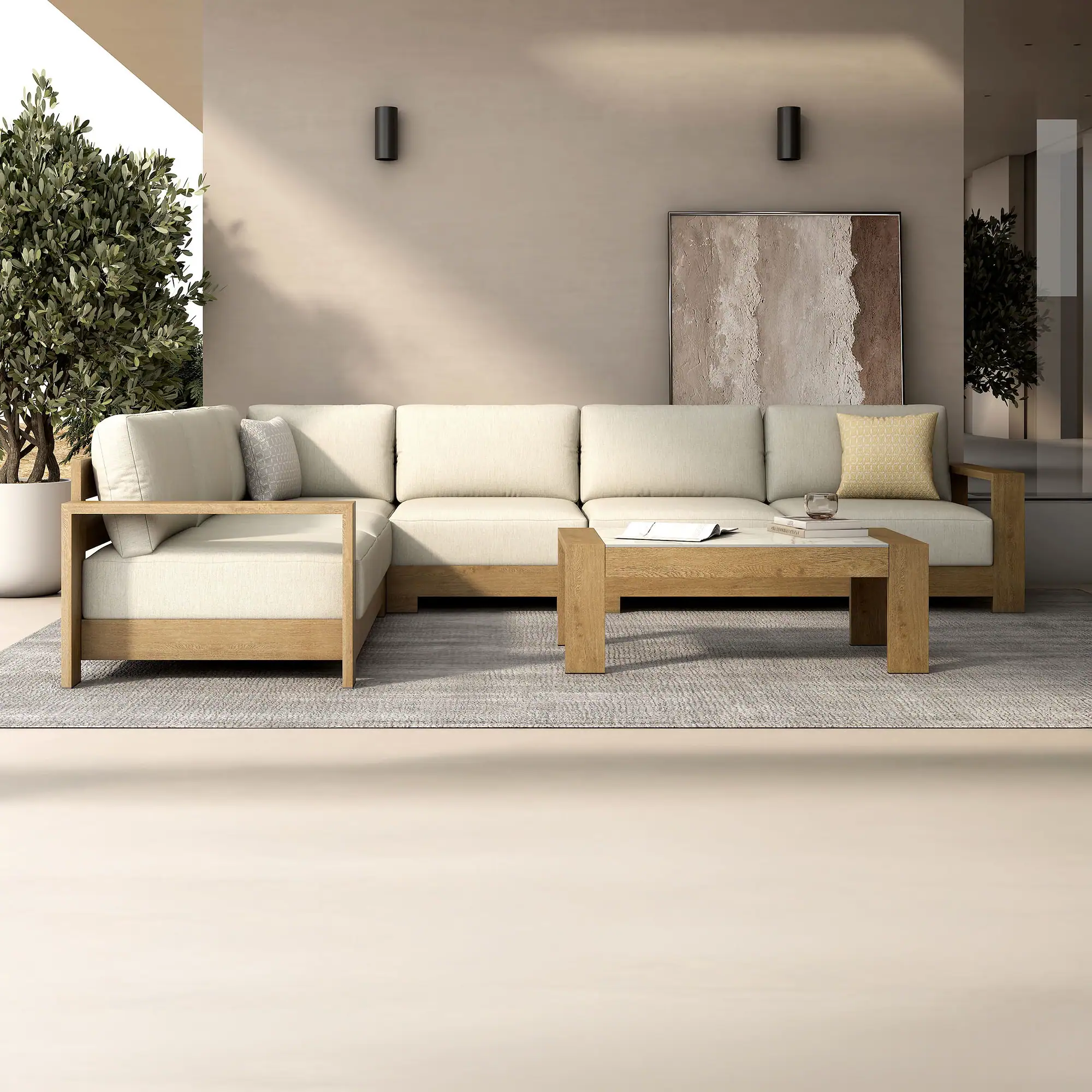 A modern outdoor living area with an L-shaped wooden sectional sofa, light cushions, a coffee table with books and a drink, and abstract art on a beige wall.