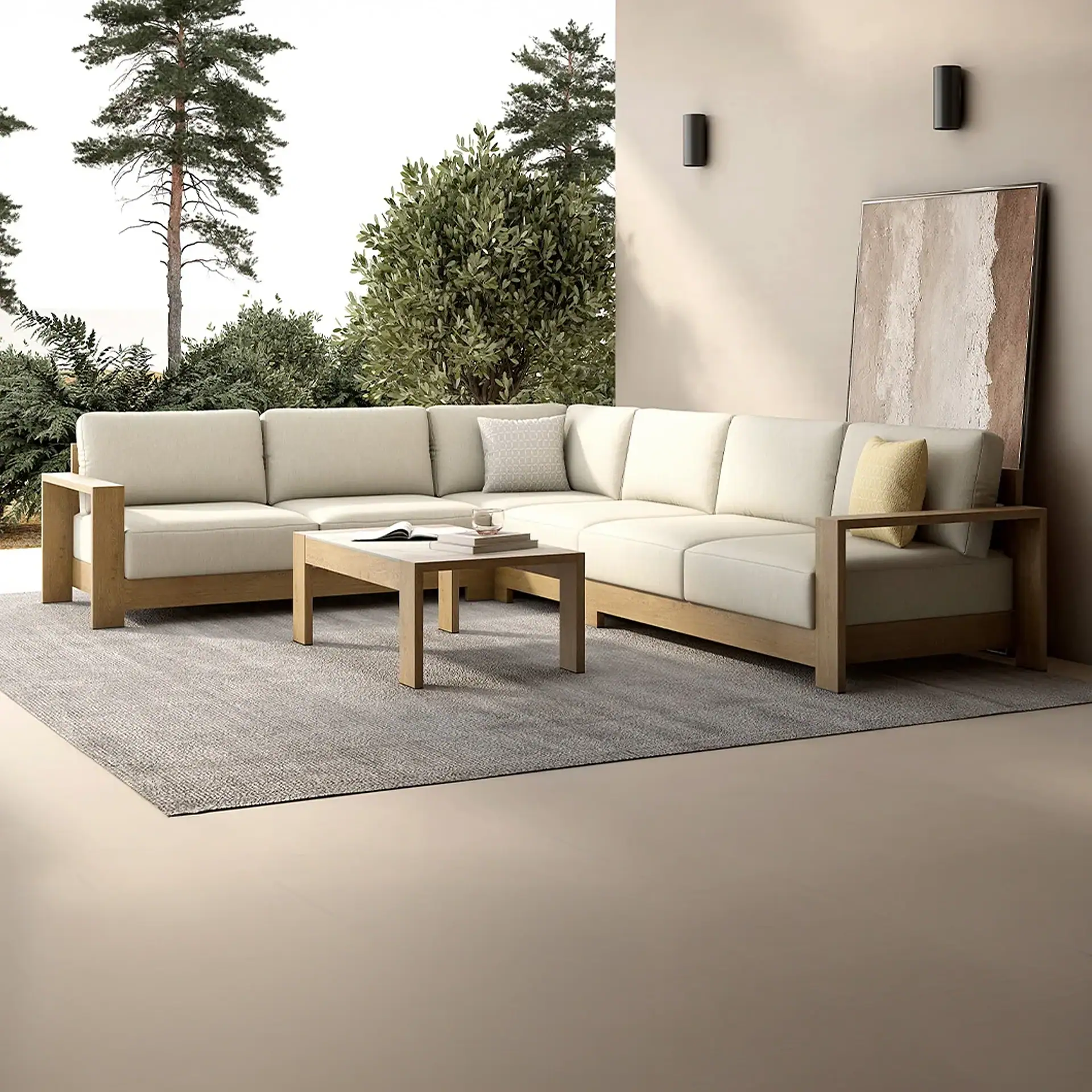 An L-shaped outdoor sectional sofa with a light wooden frame and beige cushions on a gray rug. A wooden coffee table sits in front of it, with greenery and a light wall with artwork in the background.