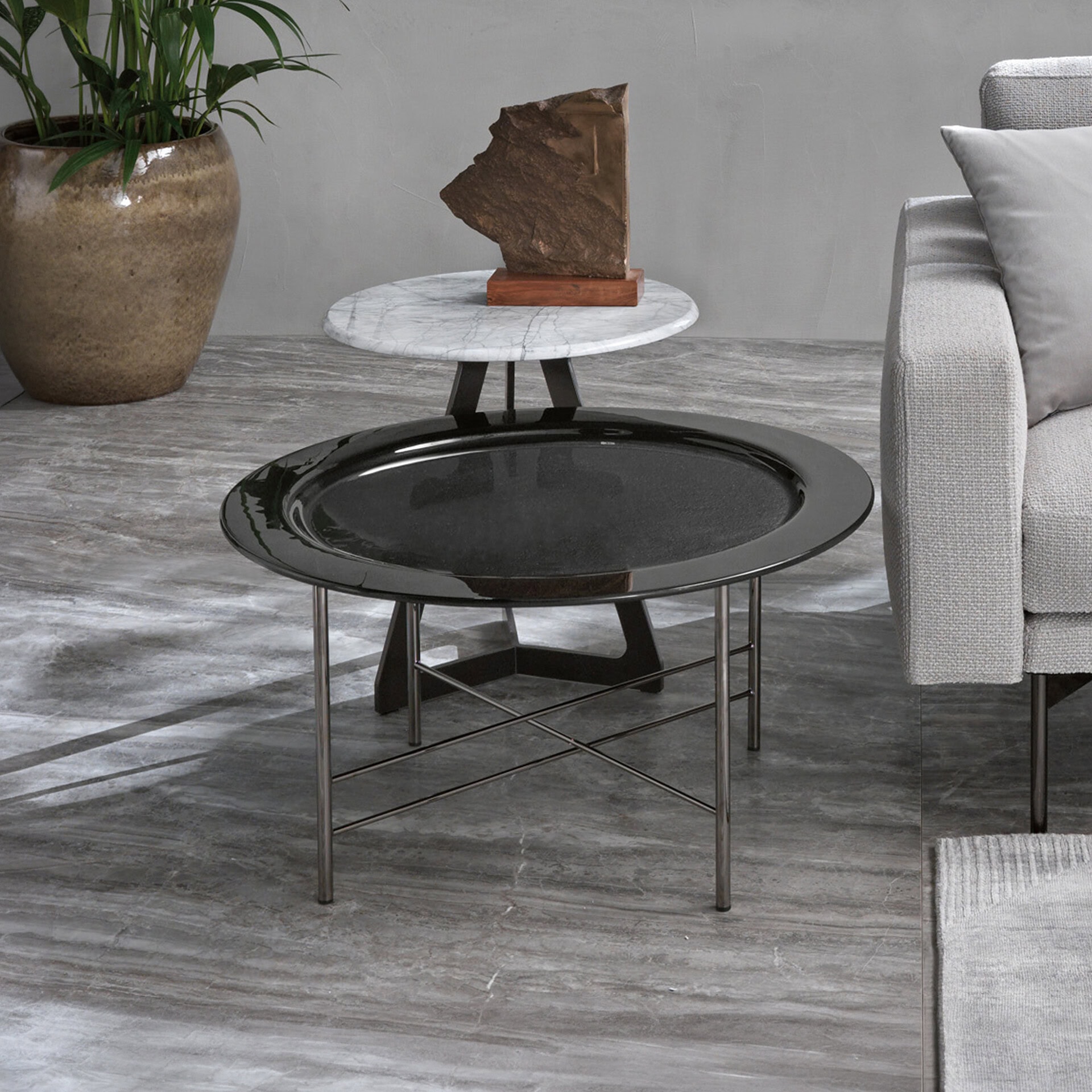 Modern glass coffee table with black top and metal legs in contemporary living room.