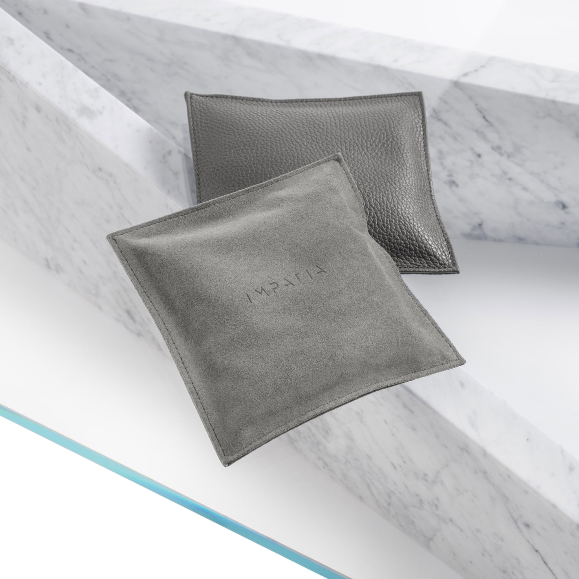Luxurious gray leather and fabric pillows on marble surface, modern home decor by Sklar Furnishings.