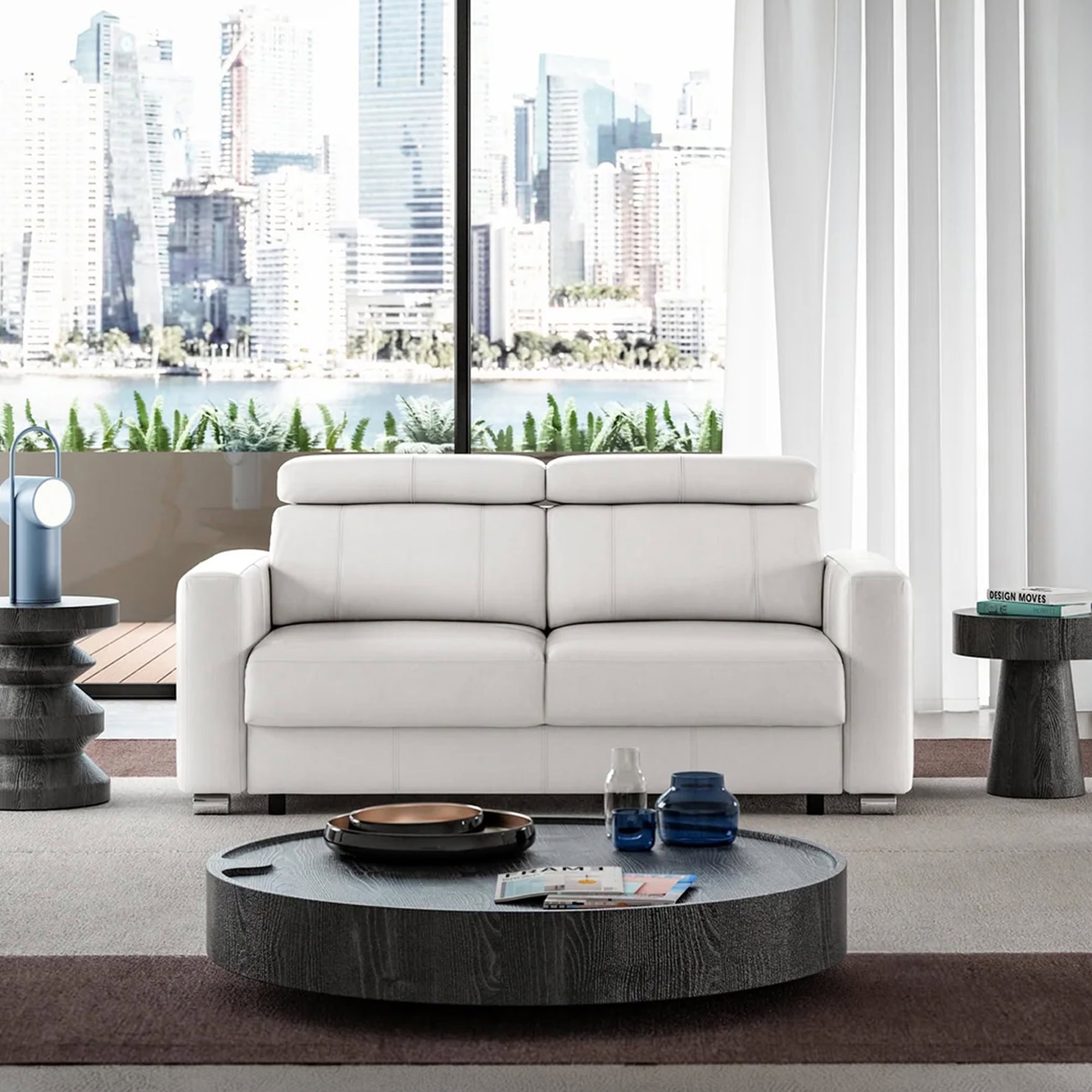 Modern white sofa with city skyline view in a contemporary living room.