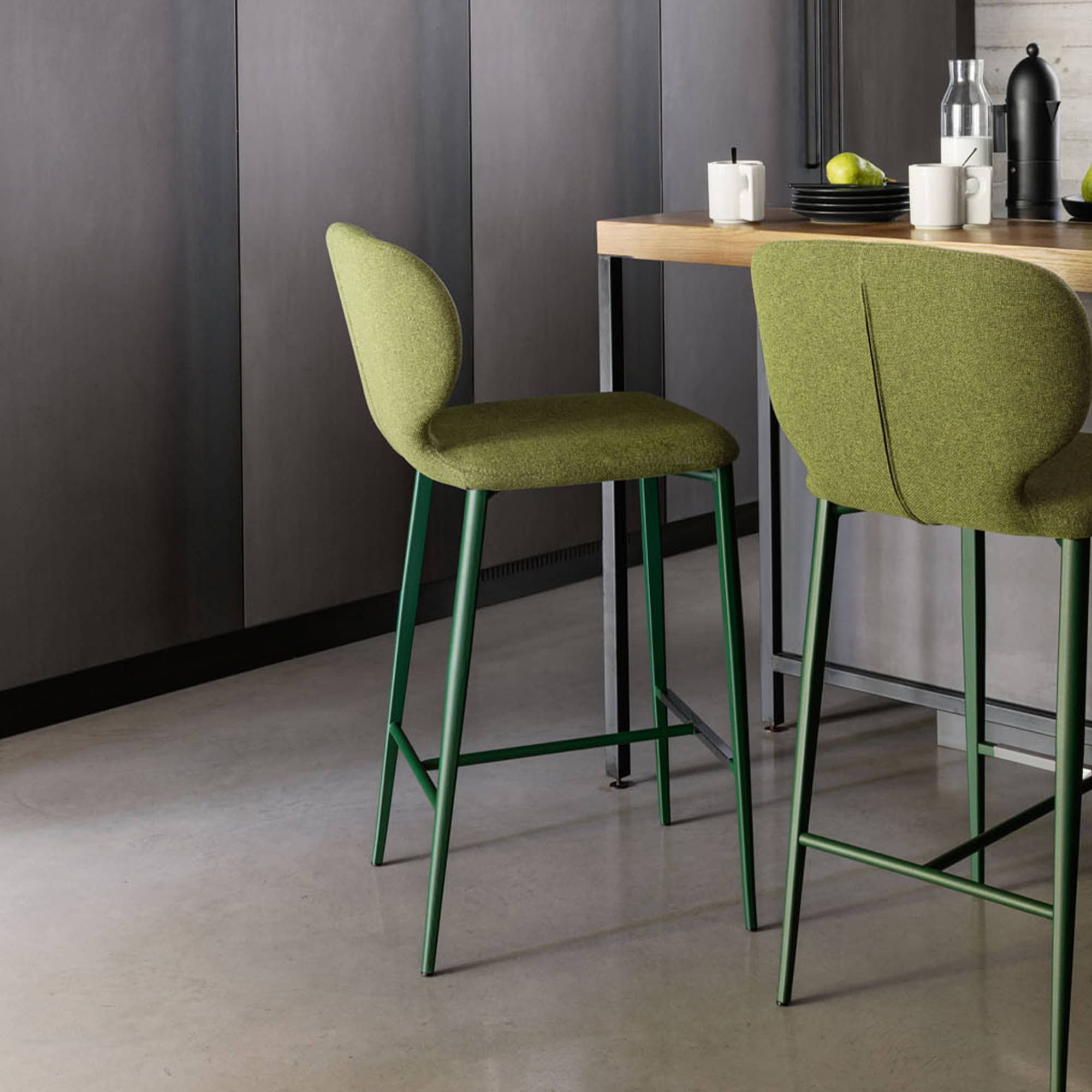 Upholstered counter stool with green fabric, perfect for modern kitchen islands and bar areas.