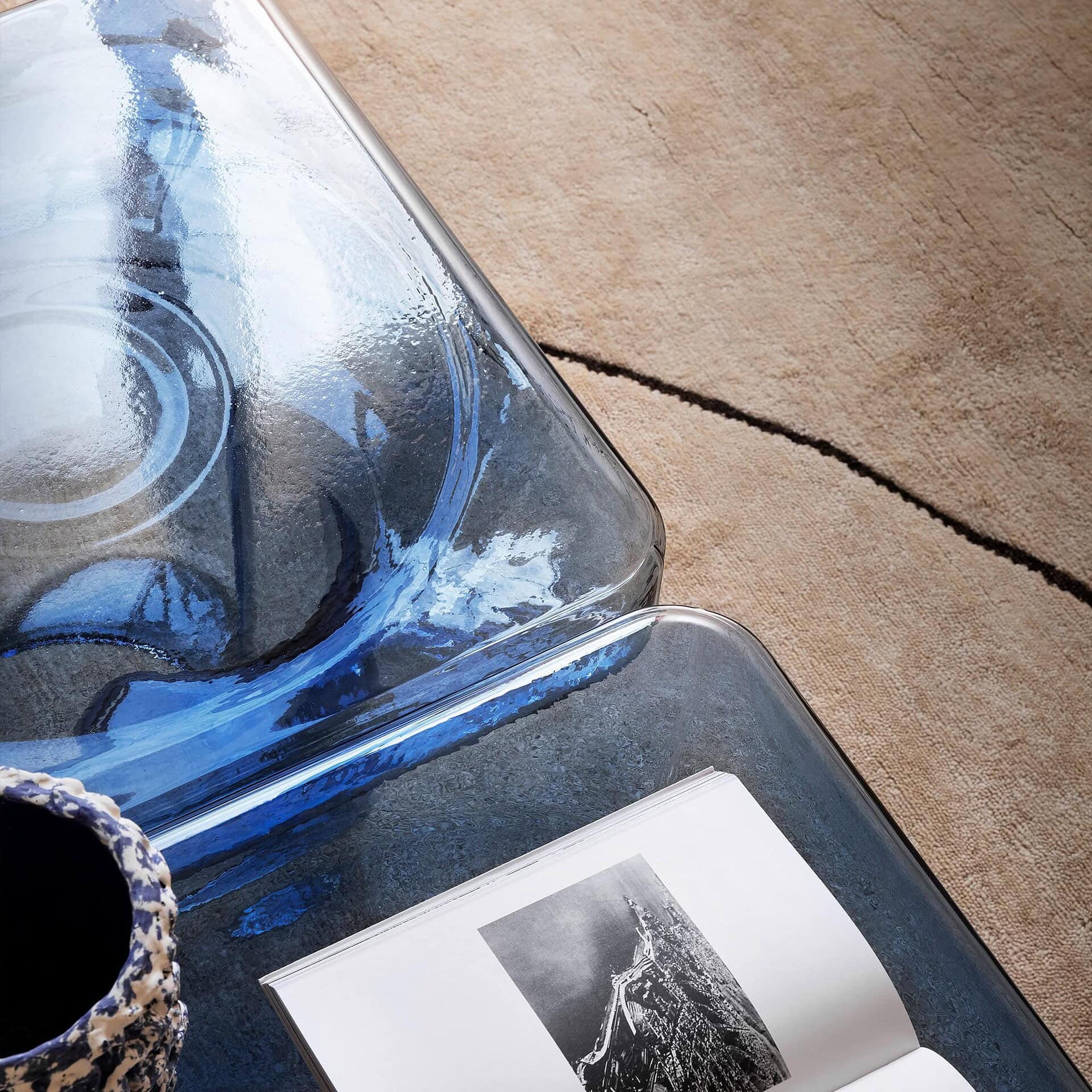 Close-up of the Soda Square Coffee Table in blue glass, highlighting the handcrafted blown glass details and tabletop reflections.