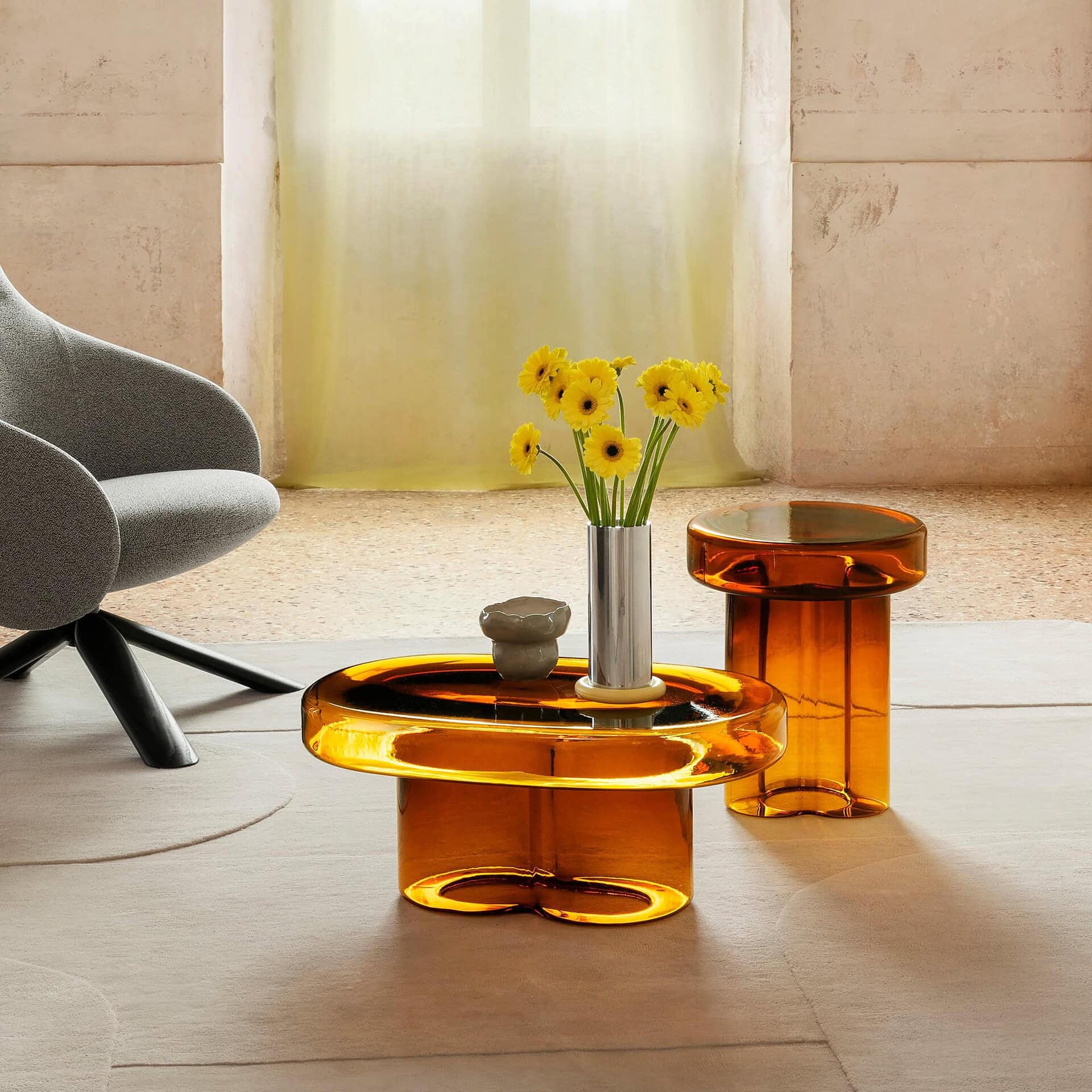 Amber Soda Oval Coffee Table in a living room setting with flowers and neutral furnishings.