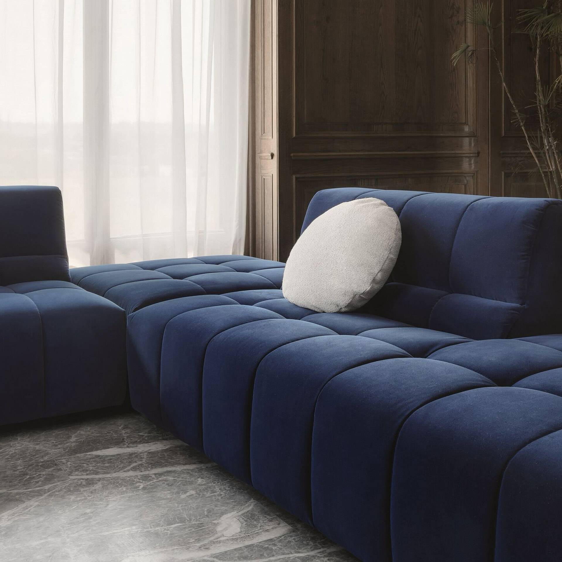 Modern blue Bric sectional sofa with plush cushions in a stylish living room.