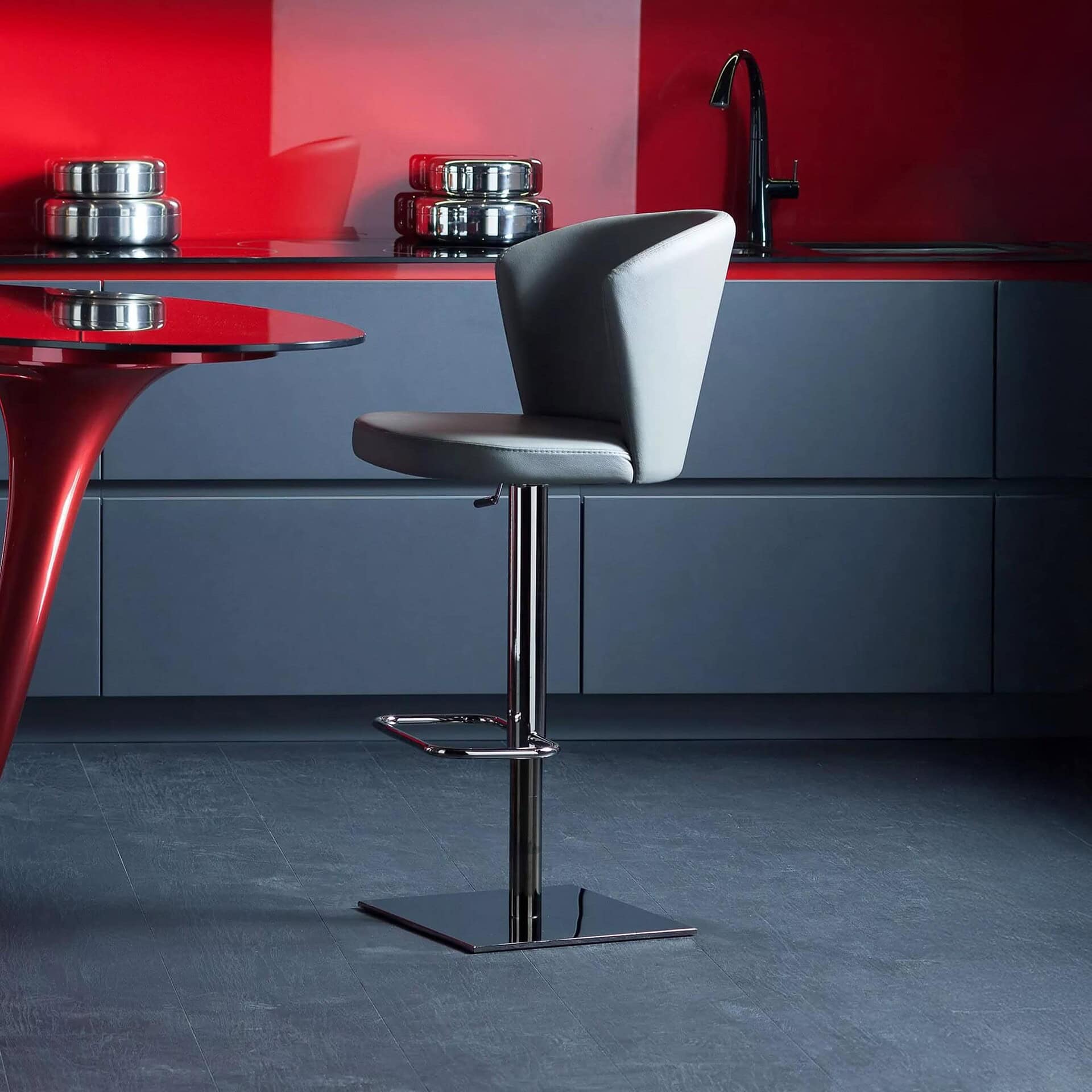 Stylish black and white kitchen bar stool with chrome base and adjustable height.