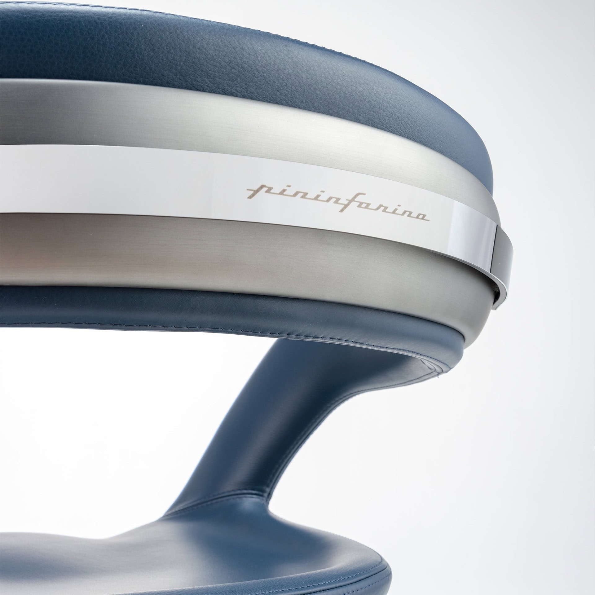Close-up of the Nido Wood Dining Chair handle in polished shiny steel, featuring engraved Pininfarina logo.