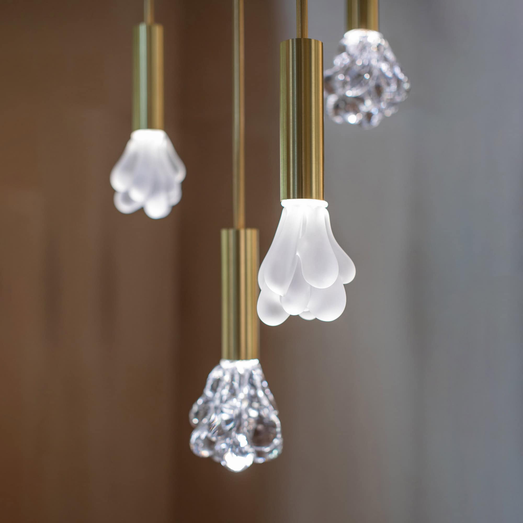 Modern SkLO pendant lights with glass and brass finishes.