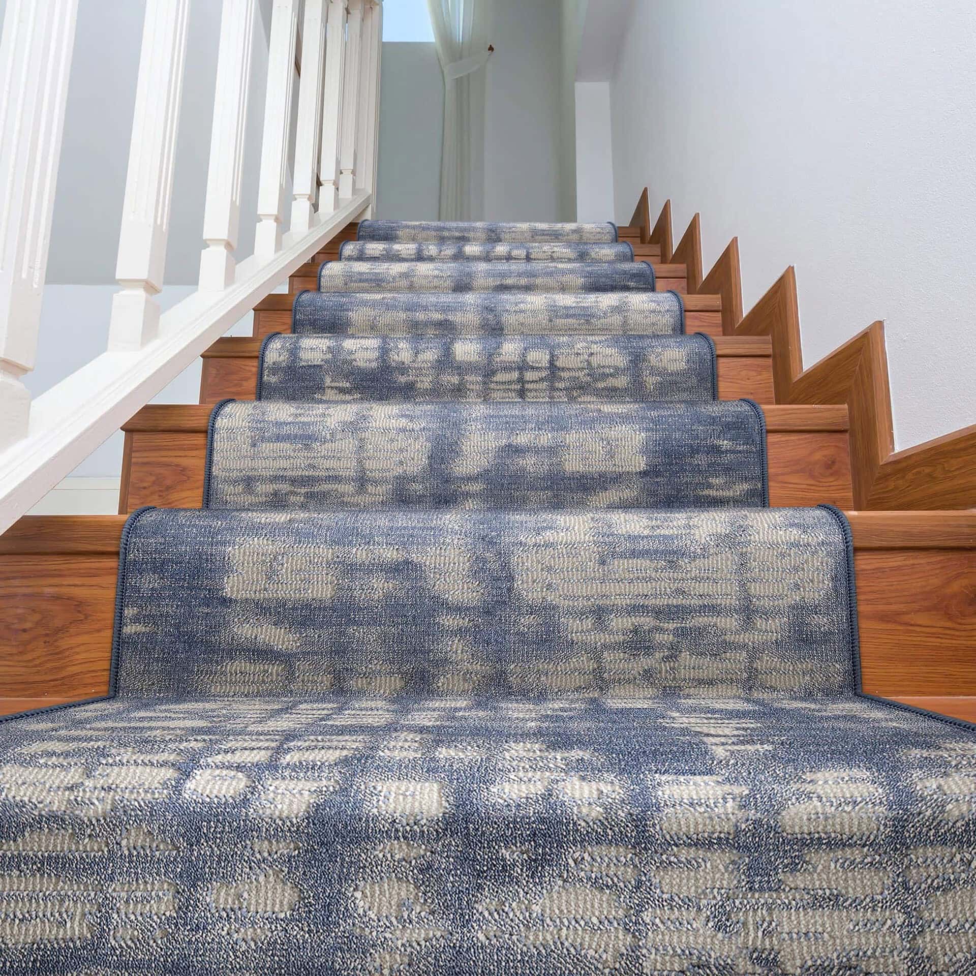 Blue patterned stair runner on wooden staircase in home interior.