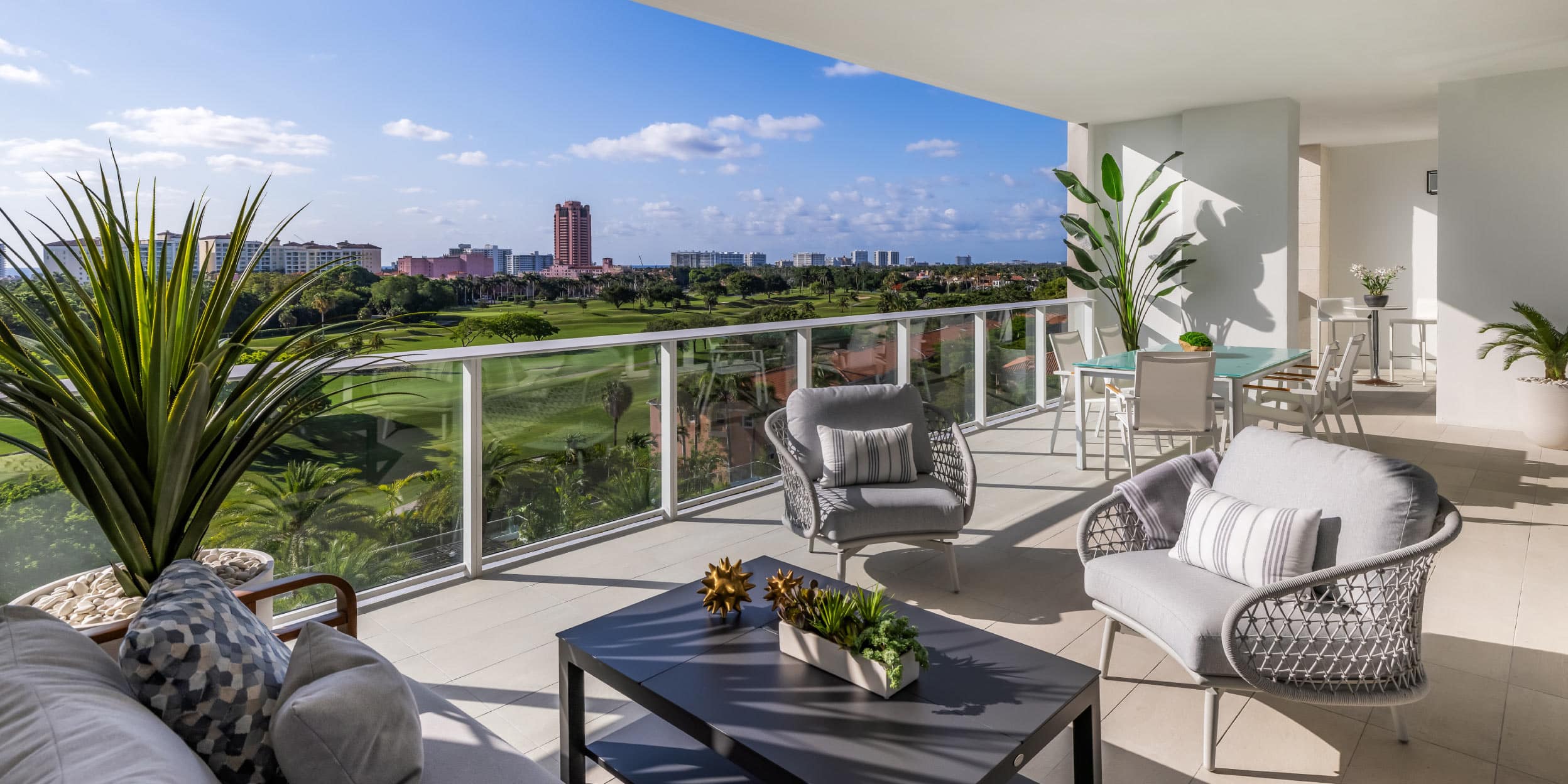 a patio with a view of a golf course and a city