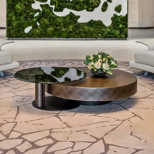 Contemporary living room featuring sleek coffee tables and a vibrant green moss wall.
