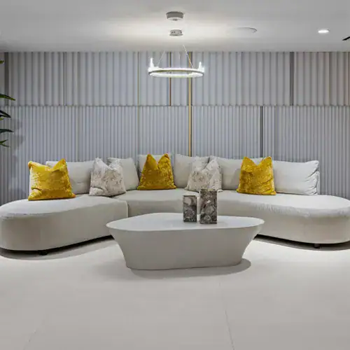 Contemporary lounge sofa with yellow accent pillows in a stylish, modern interior setting.