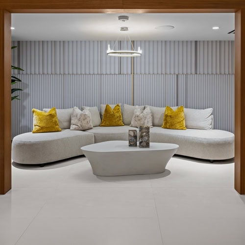 Contemporary lounge sofa with yellow accent pillows in a stylish, modern interior setting.
