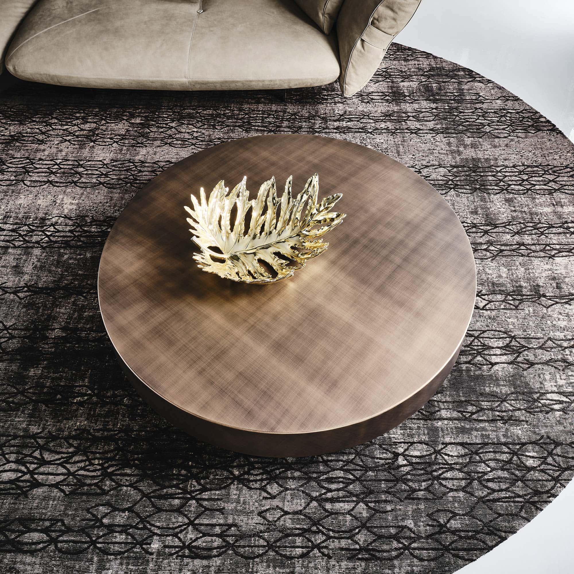 a round wooden table with a gold leaf on top