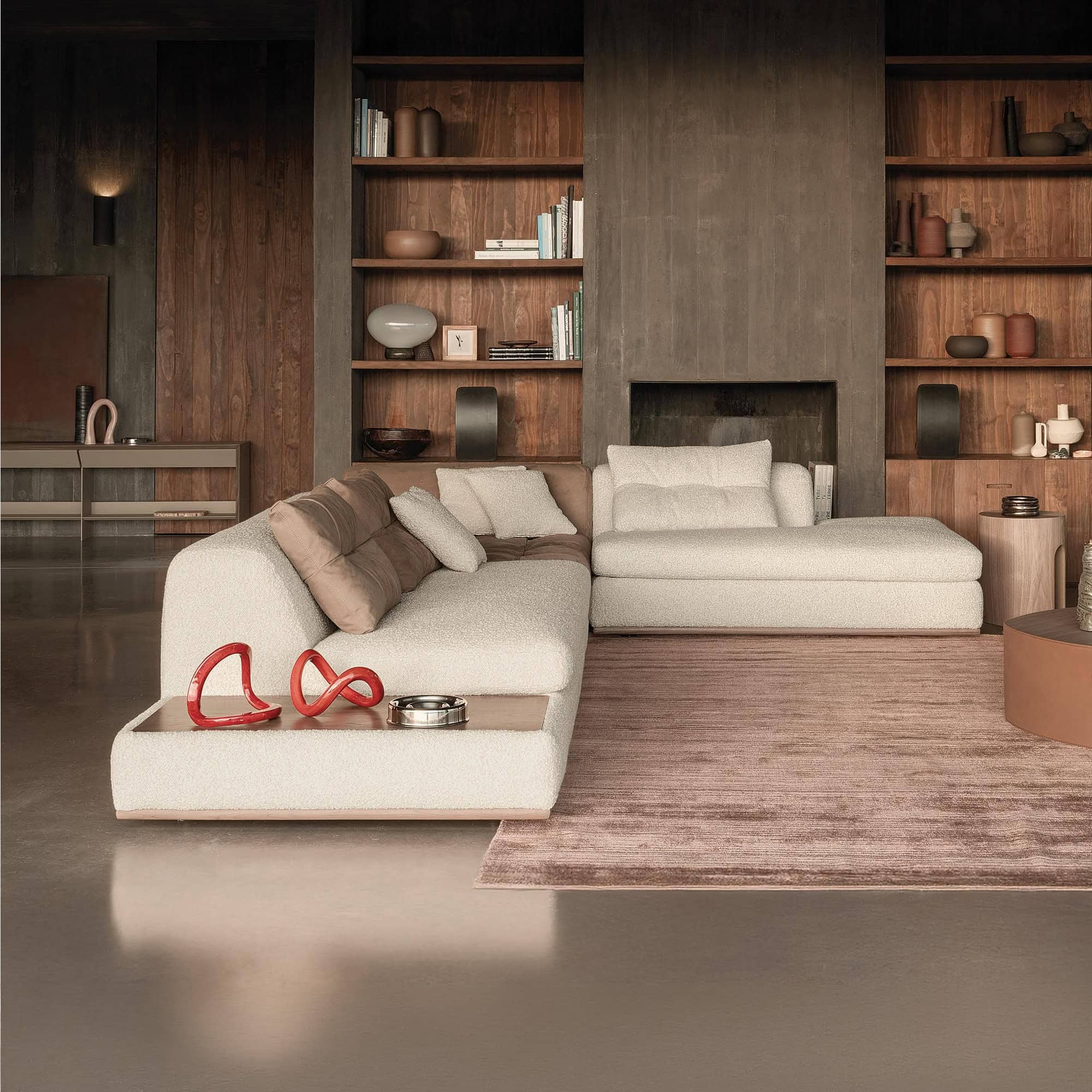 Sophisticated living room with modern white sectional sofa and wooden wall shelving by Sklar Furnishings.