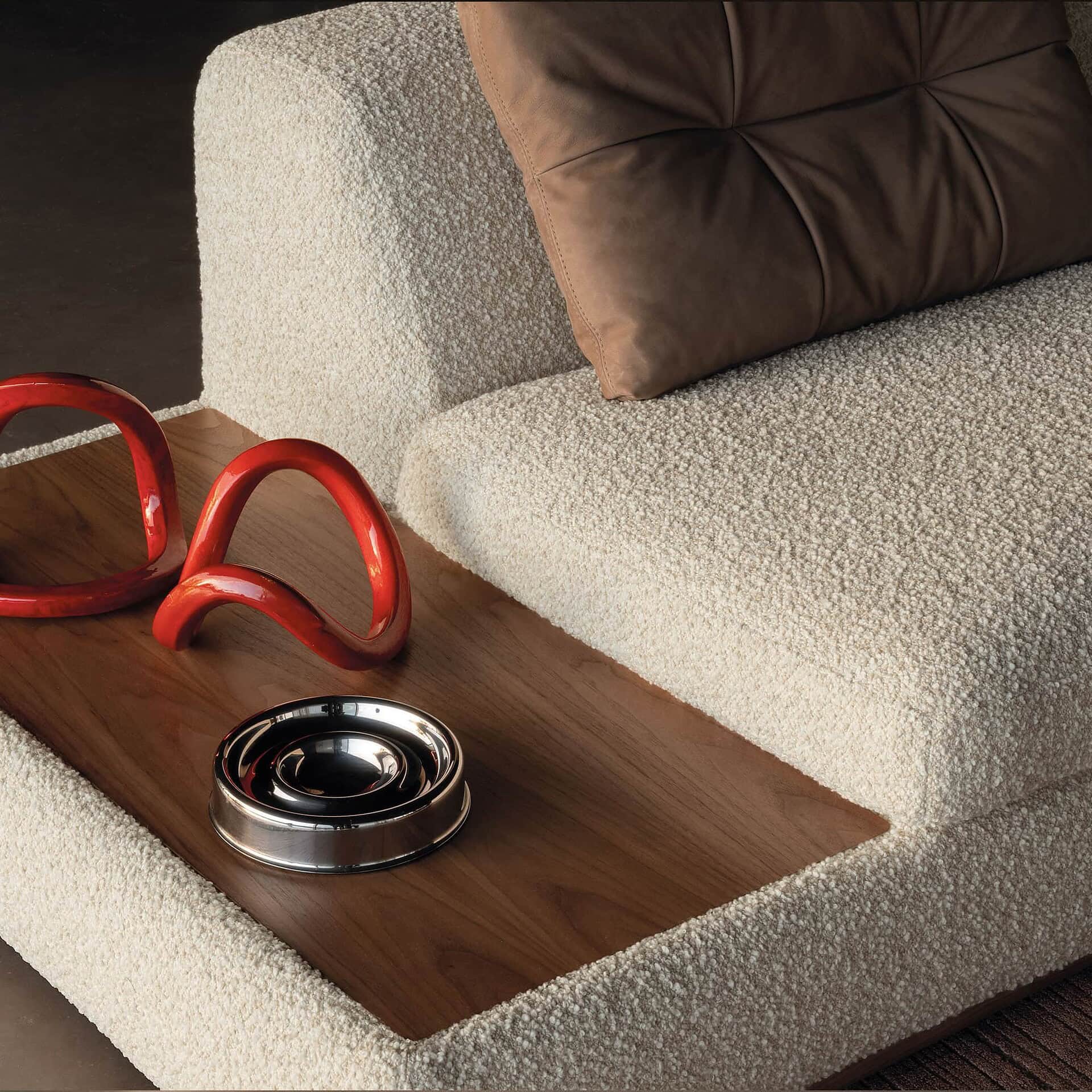 Detail shot of Montgomery Sofa with red sculptural accent on built-in wood armrest