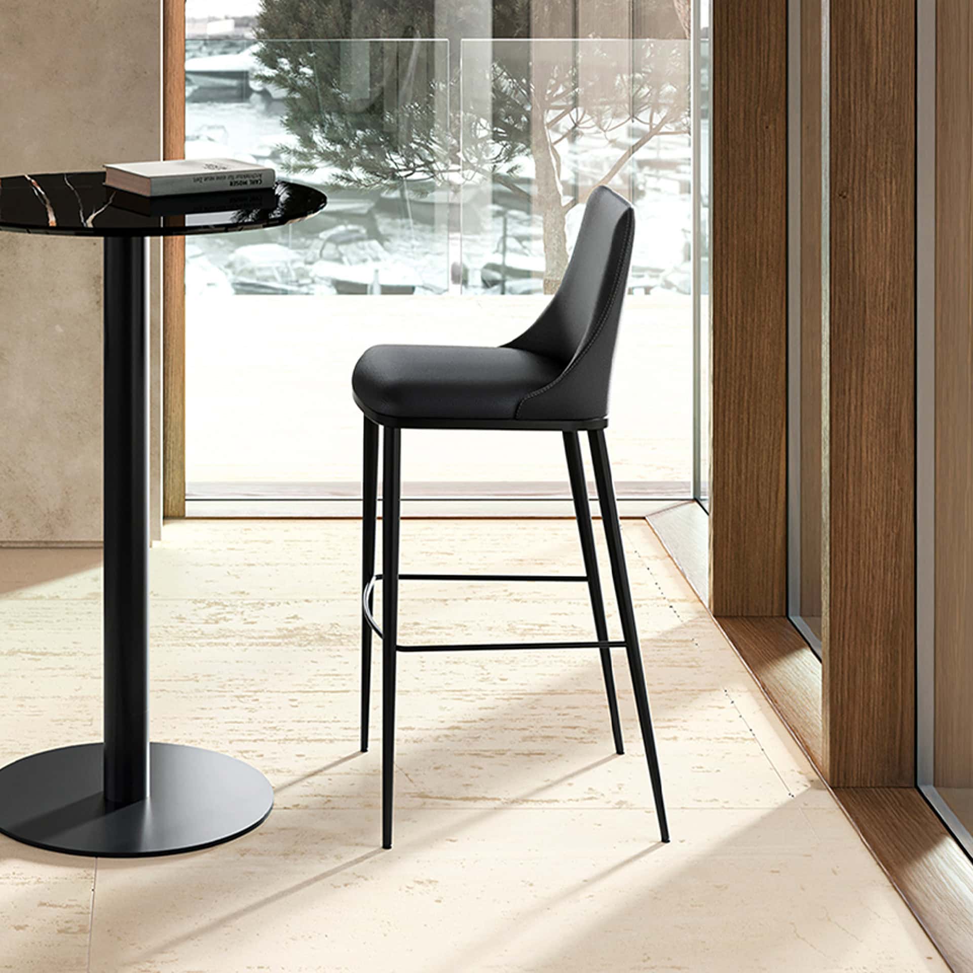Black bar stools with leather upholstery and sleek metal legs in modern dining setting.