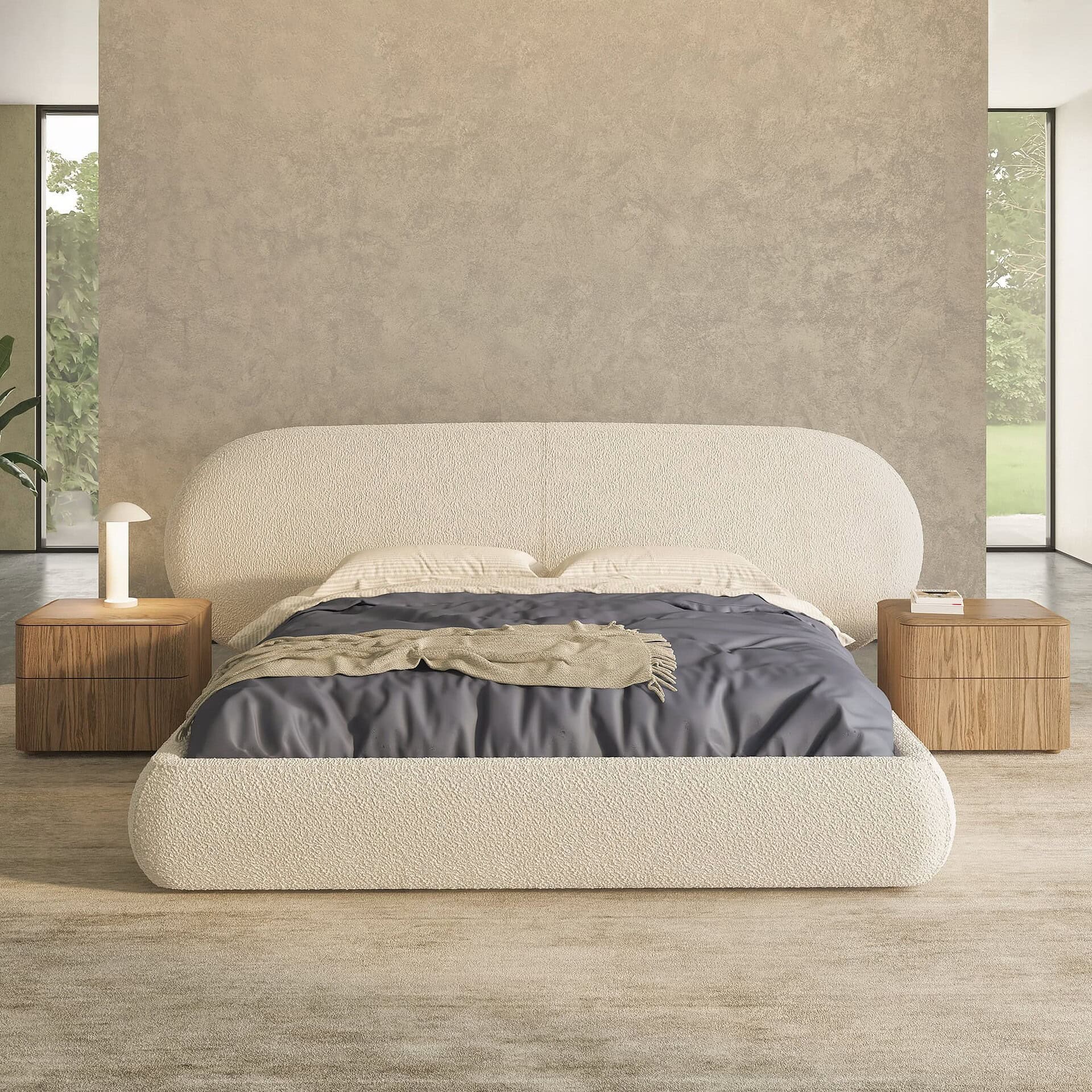 Huppé Simone Upholstered Bed in beige fabric with rounded headboard, shown in a modern bedroom