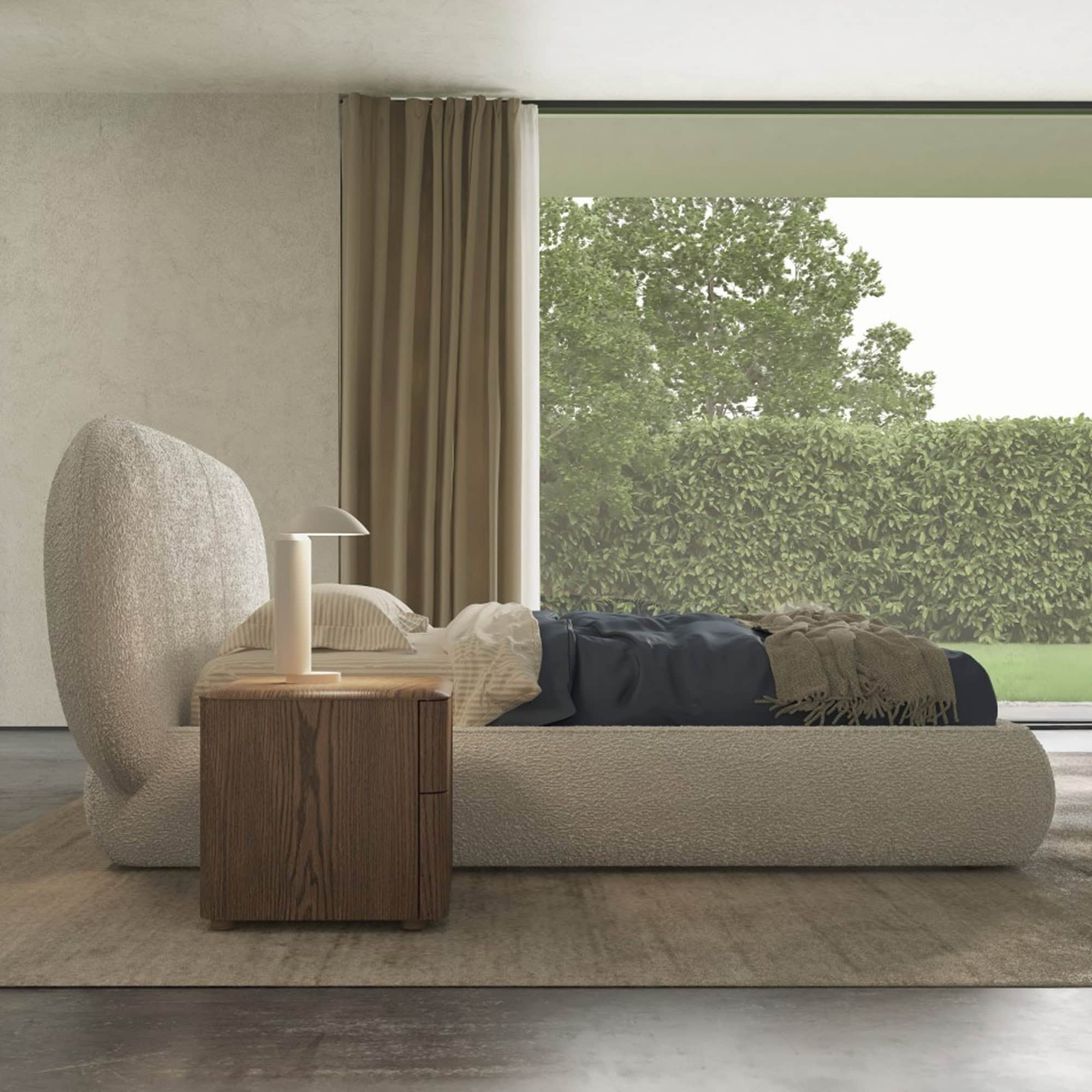 a bed with a side table next to a window
