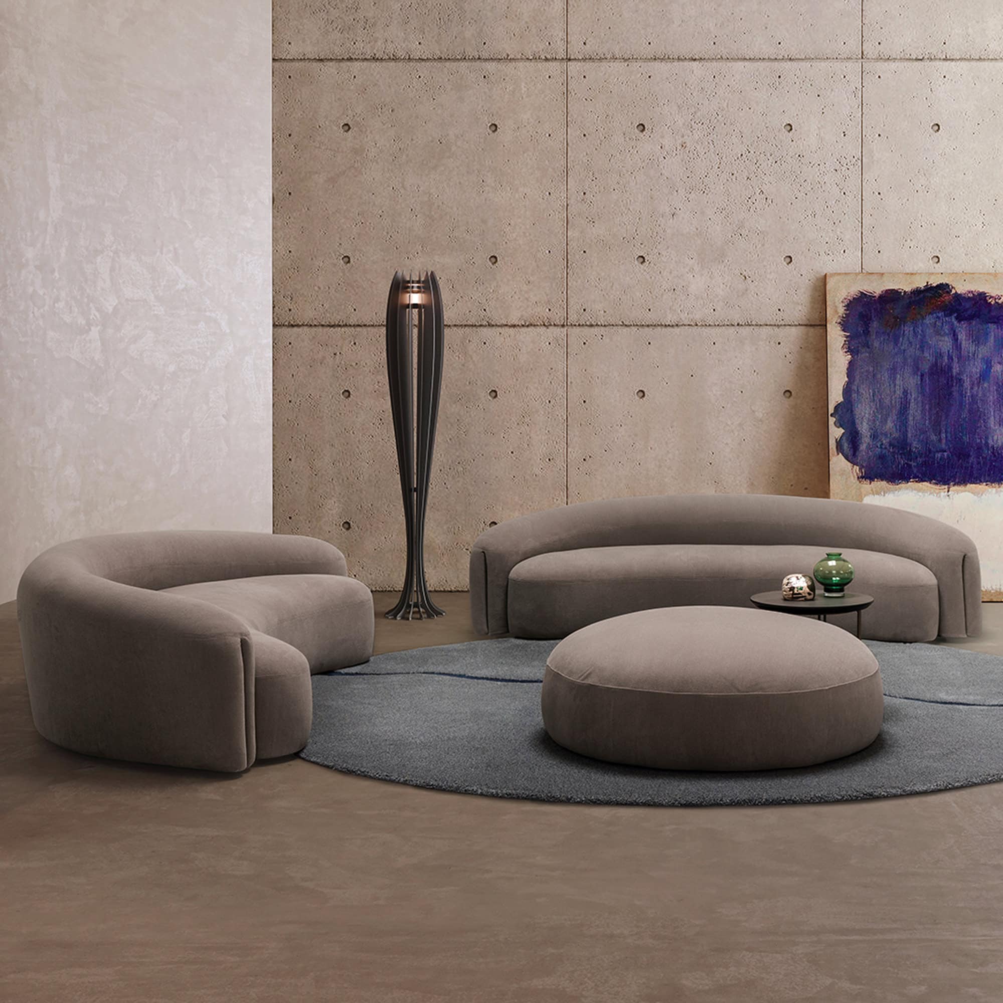 Quentin Curved Upholstered Sofas paired with matching ottomans in a contemporary lounge.