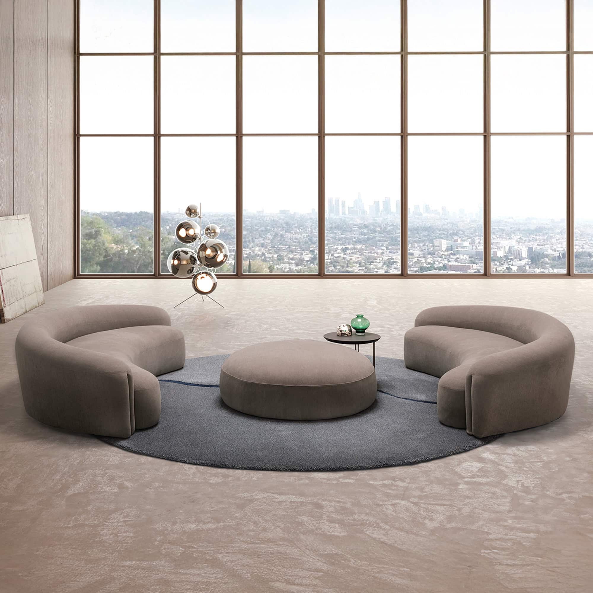 Quentin Curvo Sofa in a modern living room with large windows and circular layout.
