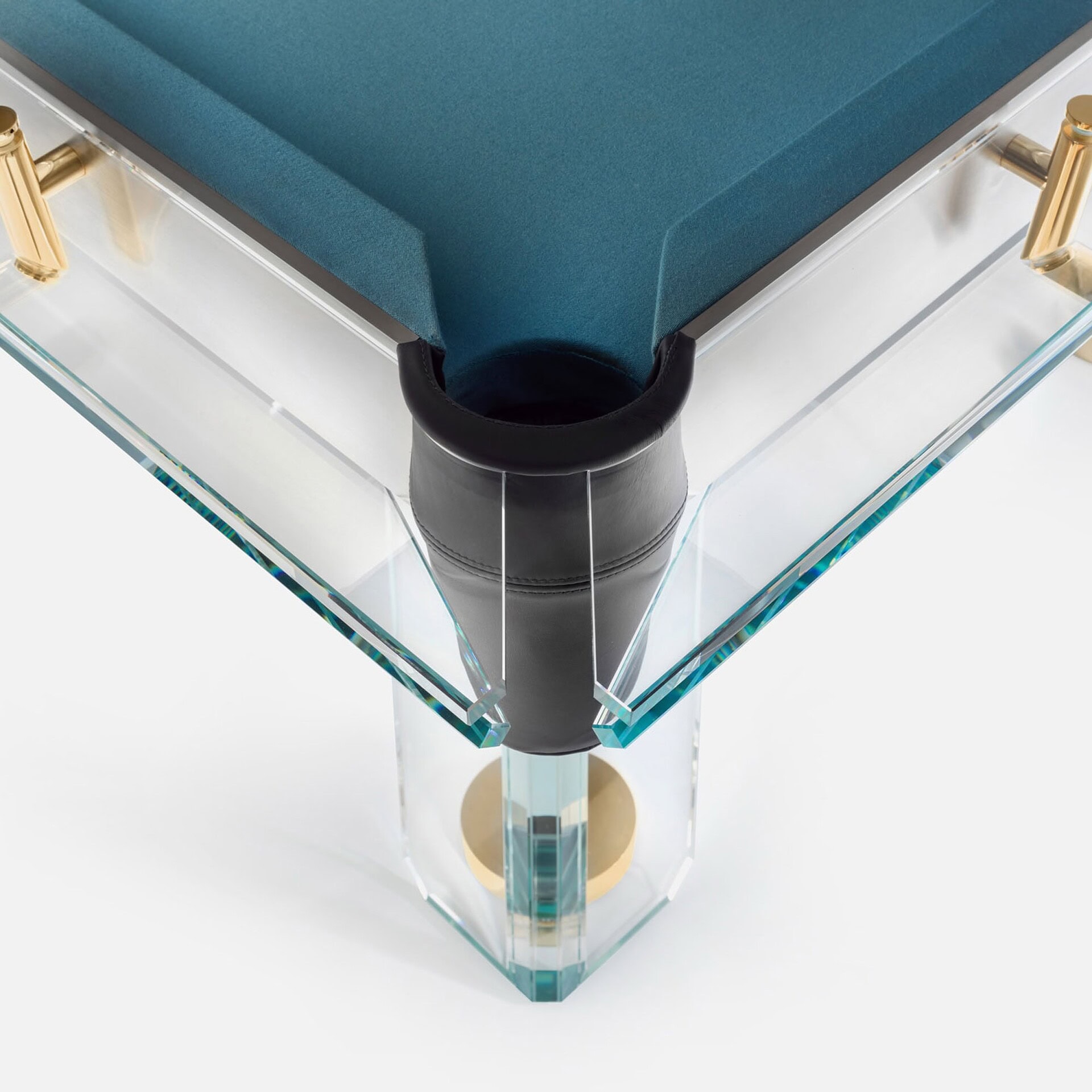 Luxurious glass pool table with gold accents and sleek black leather corner pocket details.
