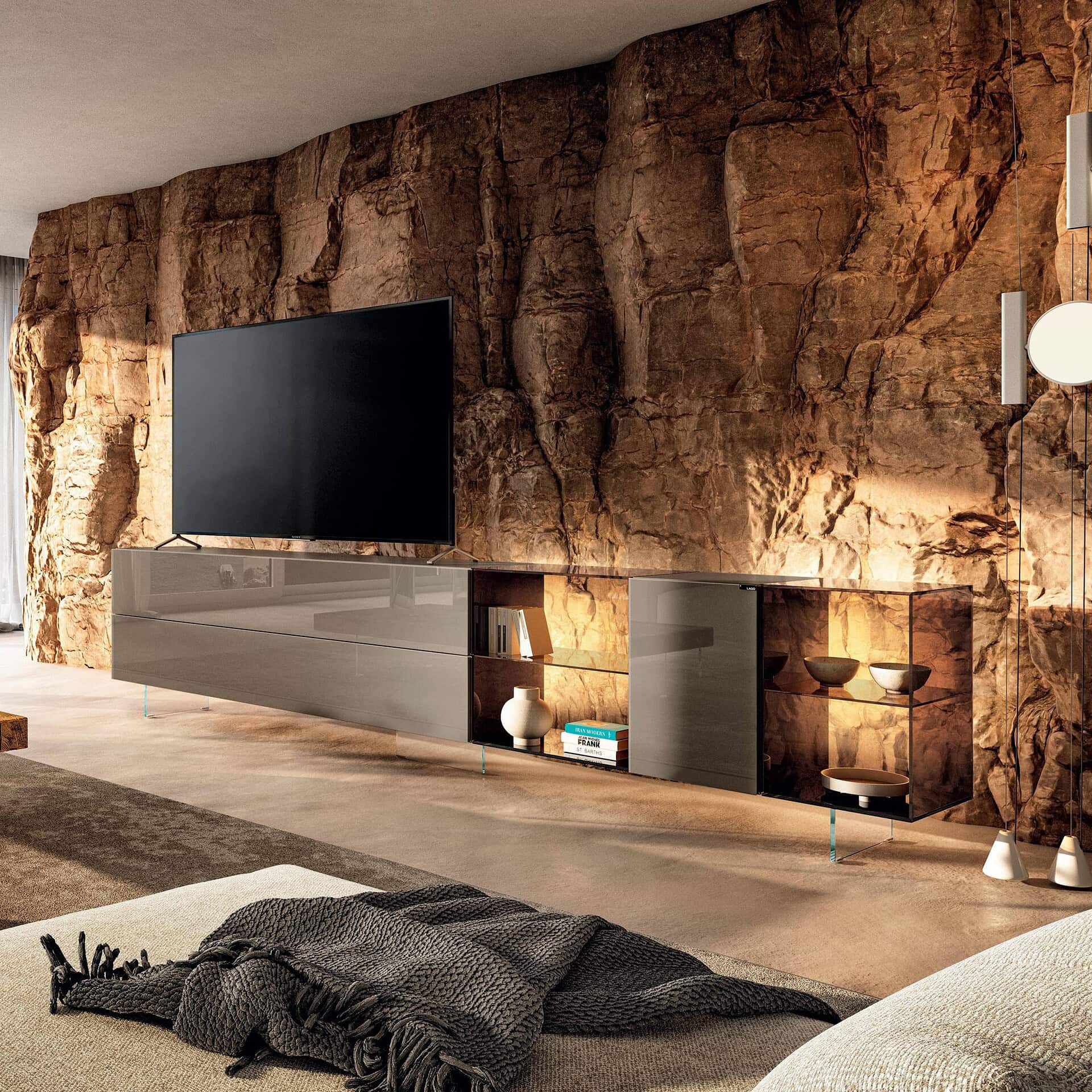Contemporary entertainment unit with sleek design against a natural rock wall.