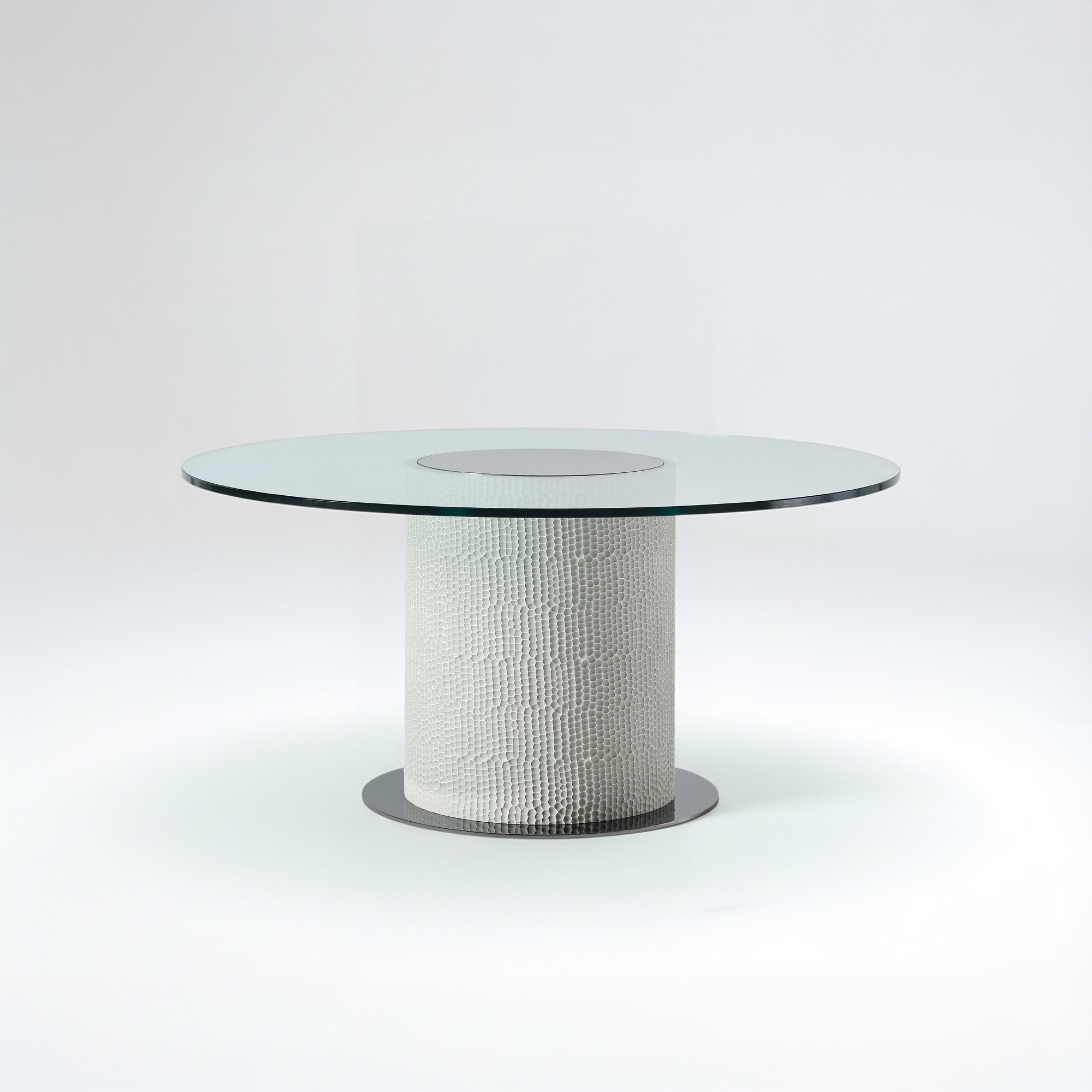 Modern Sahara round glass dining table with textured base, perfect for contemporary dining rooms.