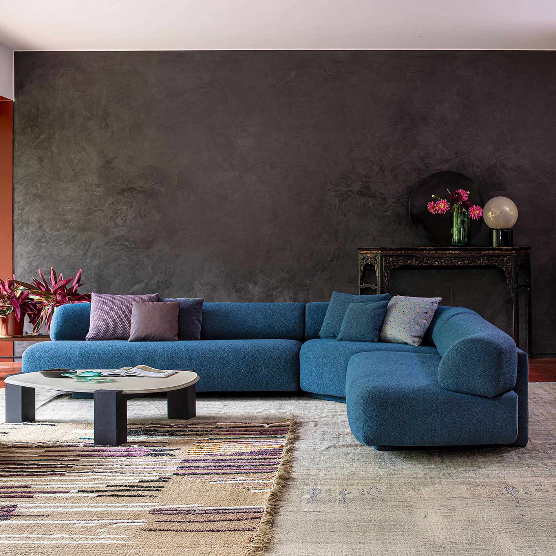 Gogan Modular Curved Sofa in bold blue upholstery placed in a contemporary living room setting.