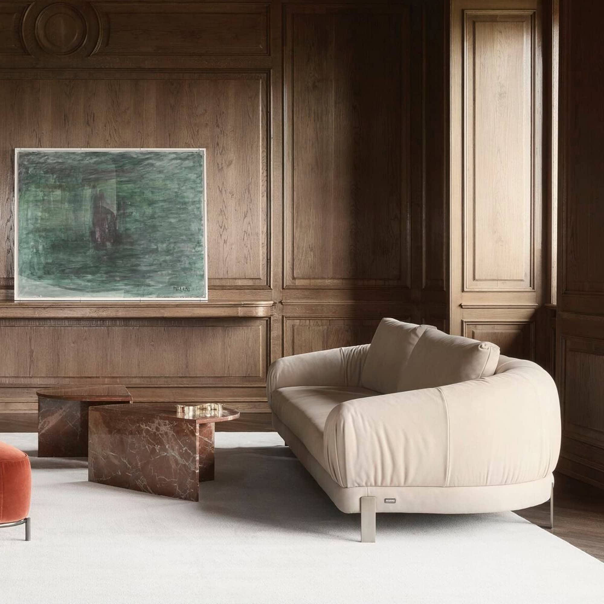 Neutral-toned Crumble Modular Sofa styled with leather ottoman in a modern lounge setting.