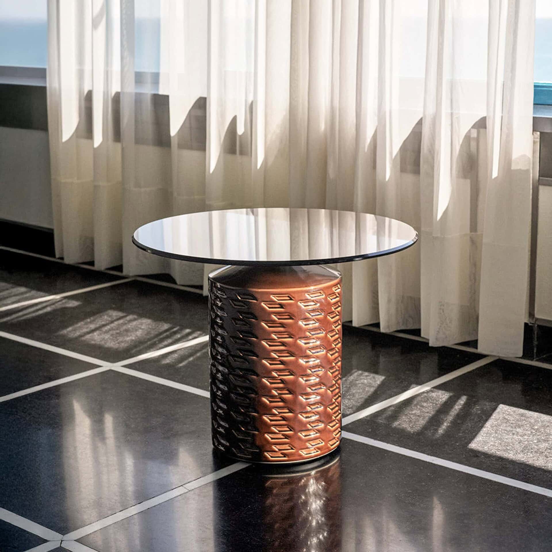 Hishi Glazed Ceramic Side Table in chocolate finish with round bronze glass top, styled in a modern living room with natural light.