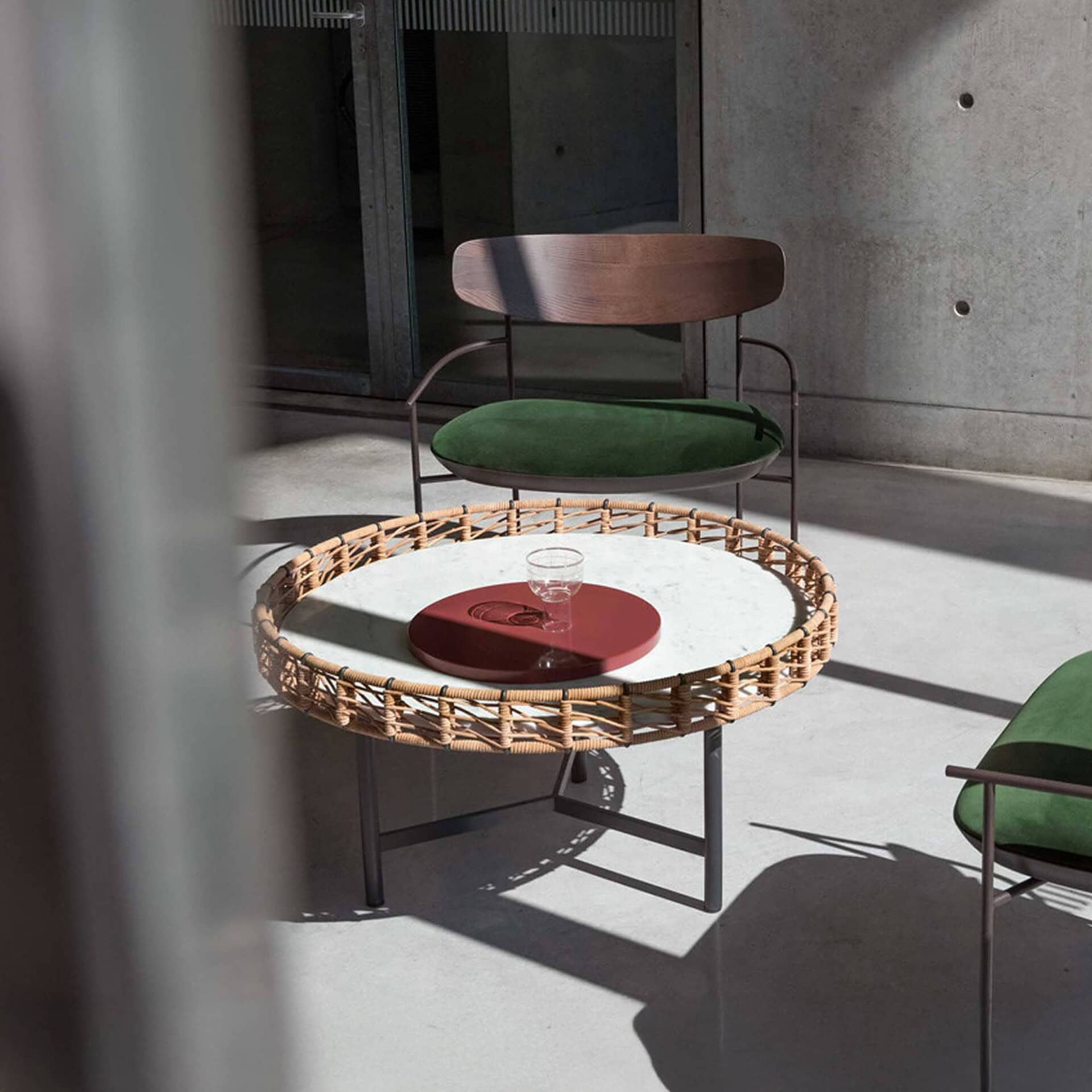 Round Ropu Woven Coffee Table with marble top and hide rope detail, styled with mid-century chairs featuring green upholstered seats.