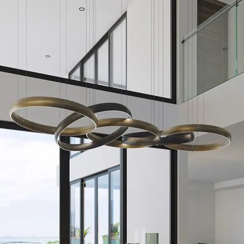 A modern chandelier made of interconnected, illuminated dark metallic rings hangs in a high-ceilinged room with large windows.