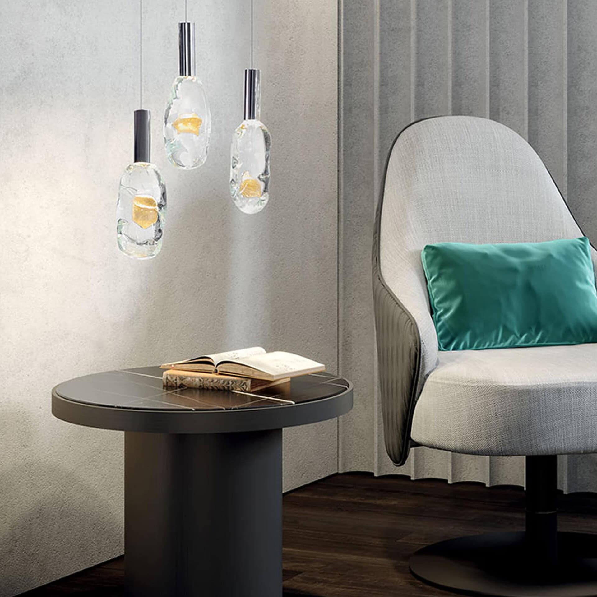 Close-up view of several Sassi Murano Glass chandelier pendants hanging above a side table next to a modern lounge chair with a green pillow.