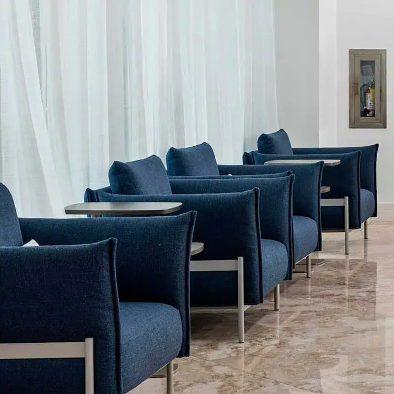 A Row Of Blue Chairs And Tables In A Room