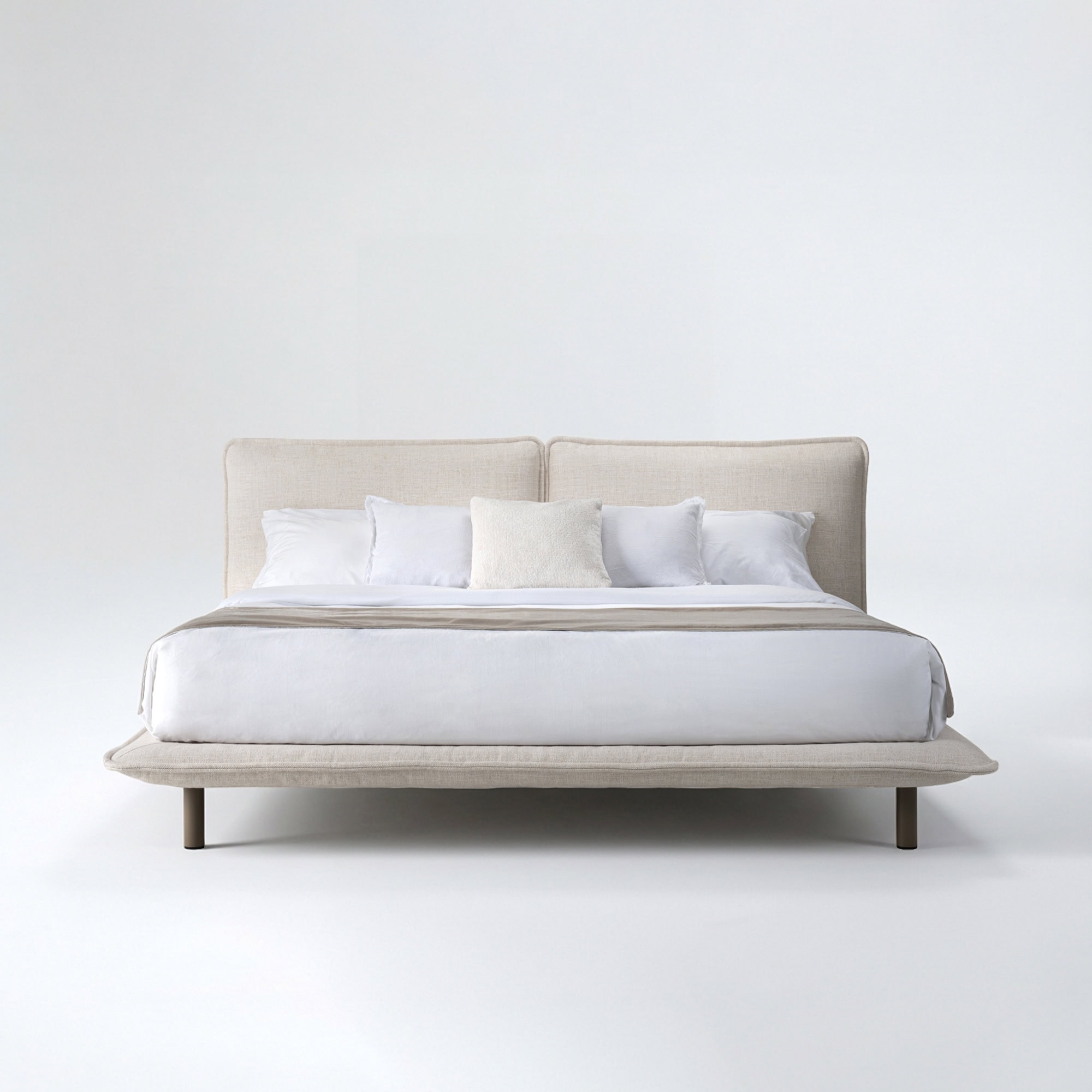 Luxurious beige upholstered bed with soft white linens, perfect for contemporary bedroom design.