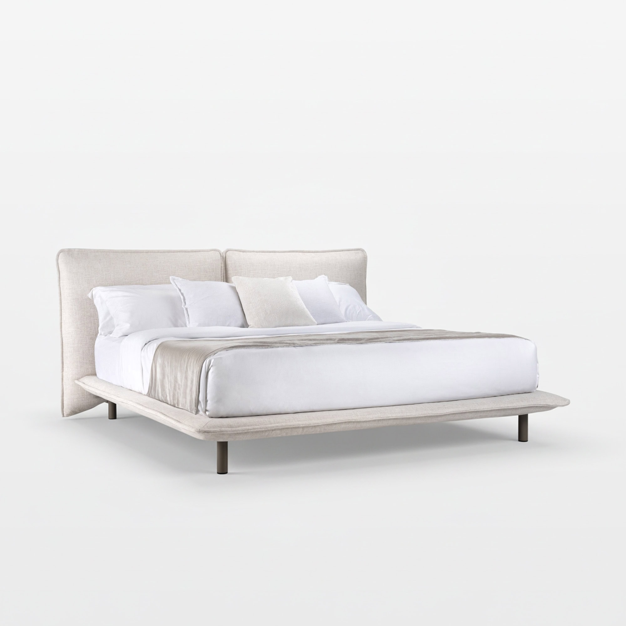 Luxurious white upholstered bed with a beige throw and multiple pillows, perfect for stylish bedroom interiors.