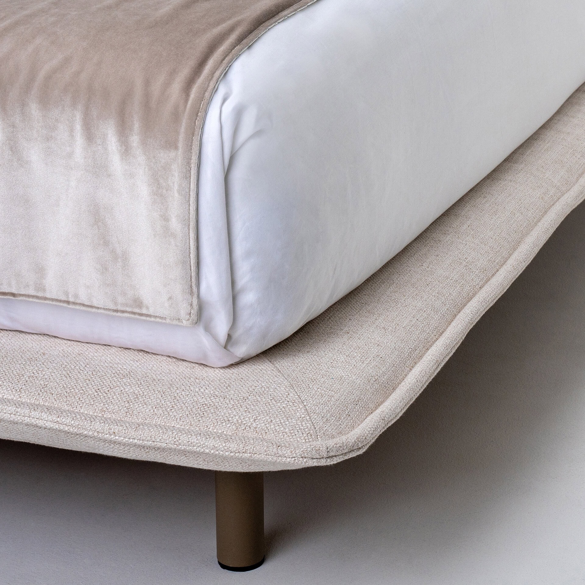 Luxurious neutral-toned bedding featuring soft fabrics, stylishly layered on a contemporary bed.