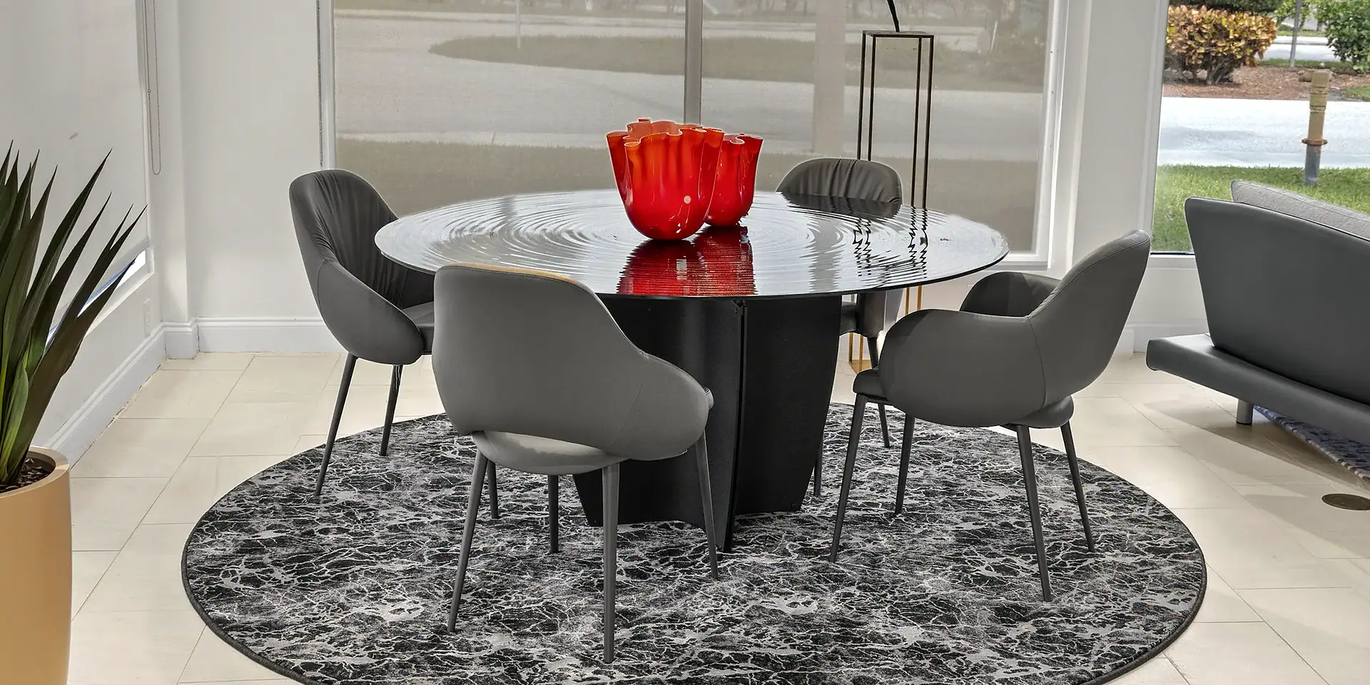 Contemporary dining room with modern black round table and stylish gray chairs, perfect for elegant gatherings.