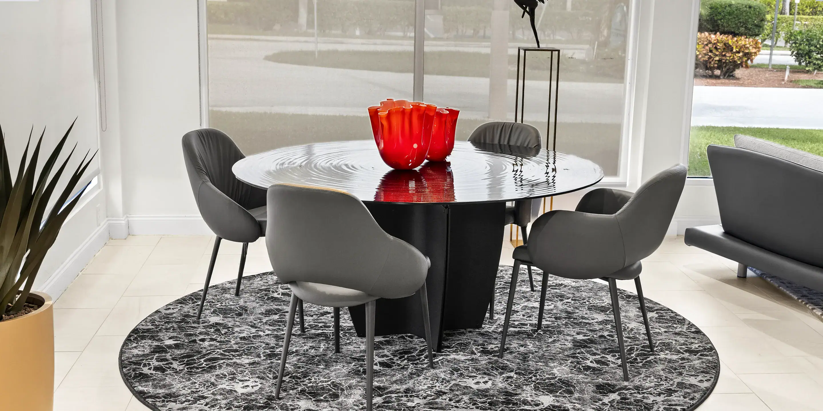 Contemporary dining room with modern black round table and stylish gray chairs, perfect for elegant gatherings.