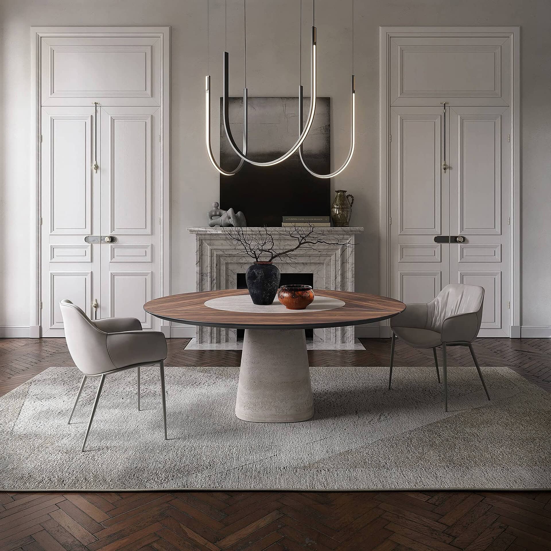 A luxurious dining room with a round wooden table, modern grey chairs, and a unique curved LED chandelier. A marble fireplace and ornate white doors are in the background, over a herringbone floor and light rug.