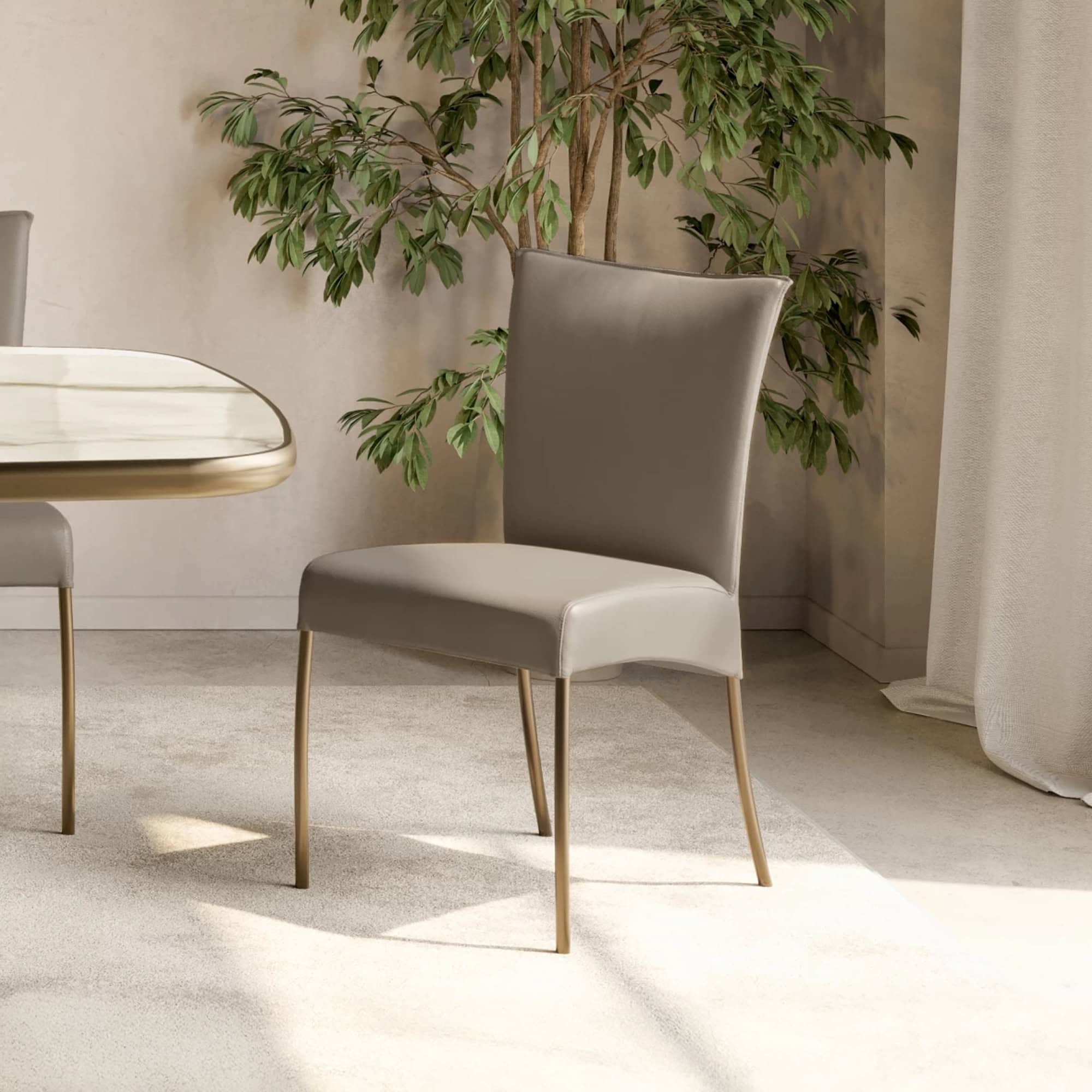 Alessia dining chair with metal legs in taupe upholstery beside a marble dining table