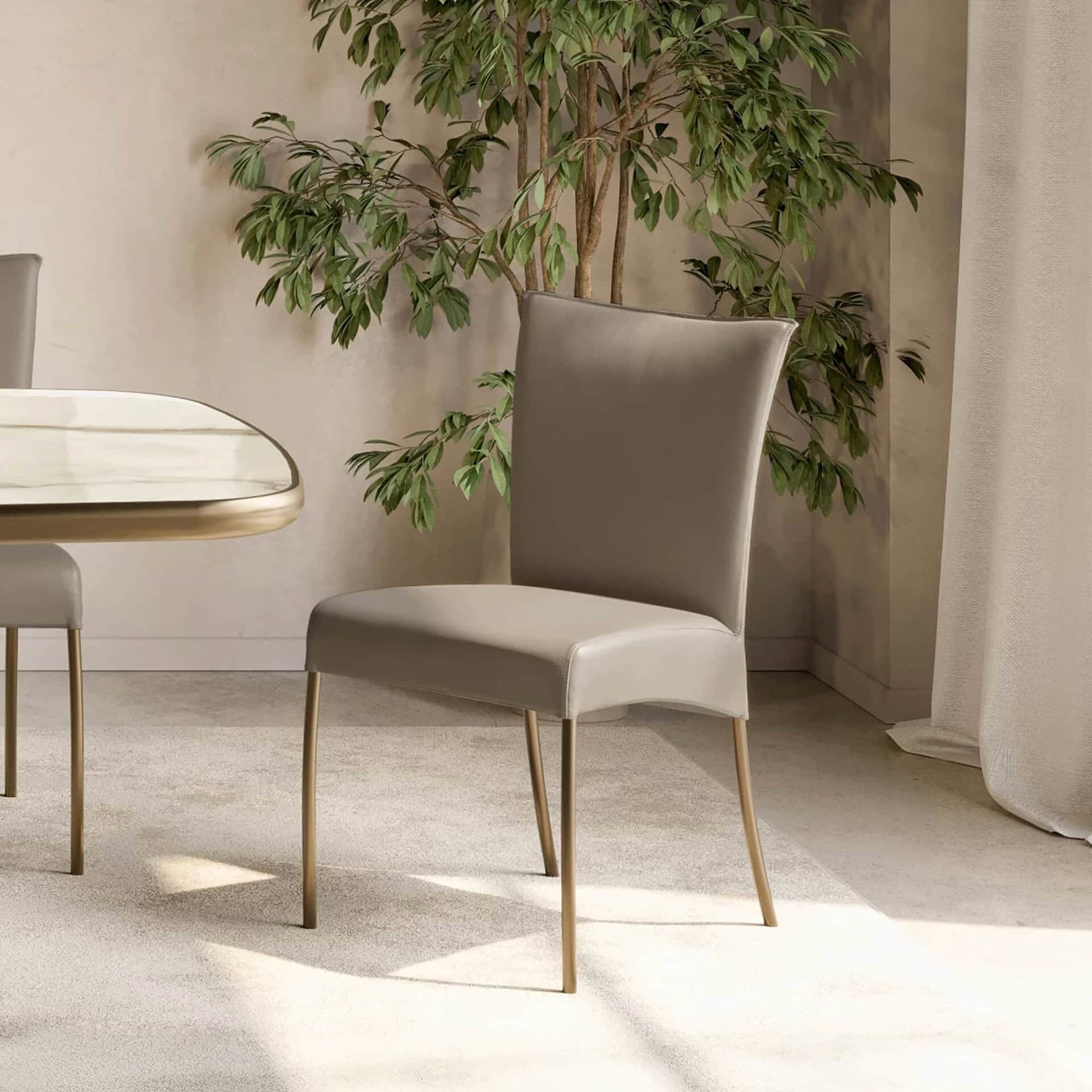 Alessia dining chair with metal legs in taupe upholstery beside a marble dining table