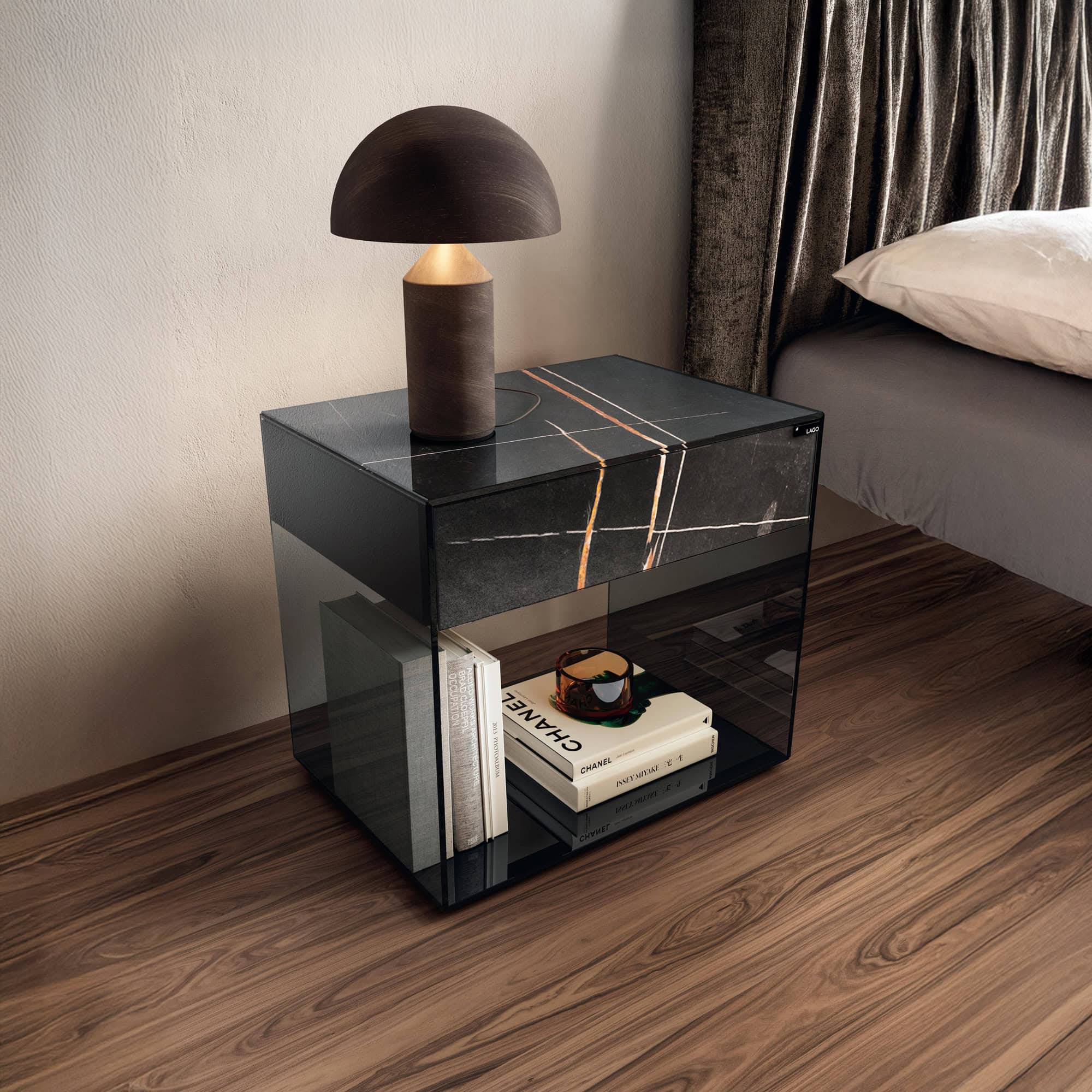 Lago UpGlass Bedside Table in smoked grey glass finish, shown in a contemporary bedroom setting with storage space underneath.