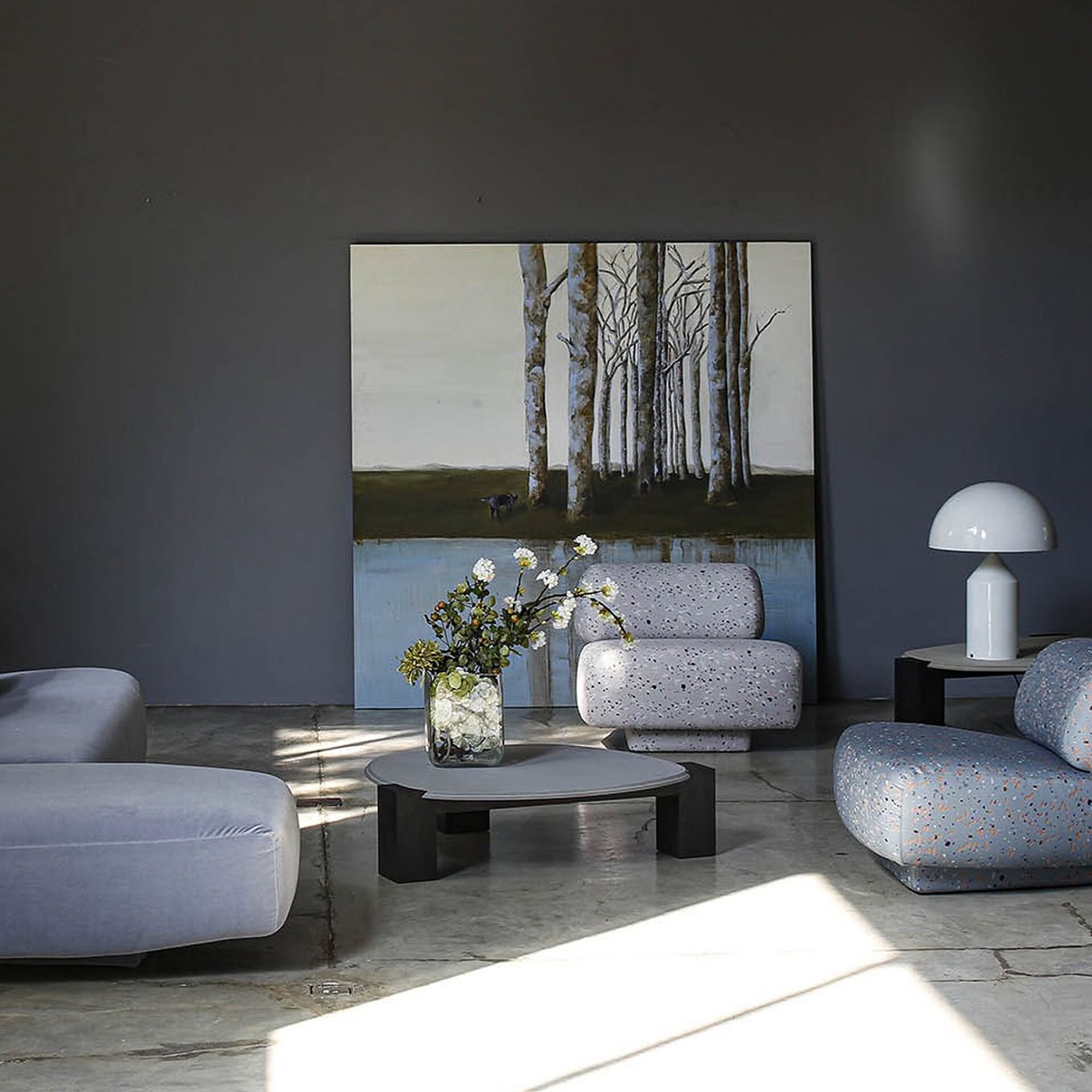 Gogan Sculptural Low Coffee Table with marble top showcased in a contemporary living room with dark walls and minimalist decor.