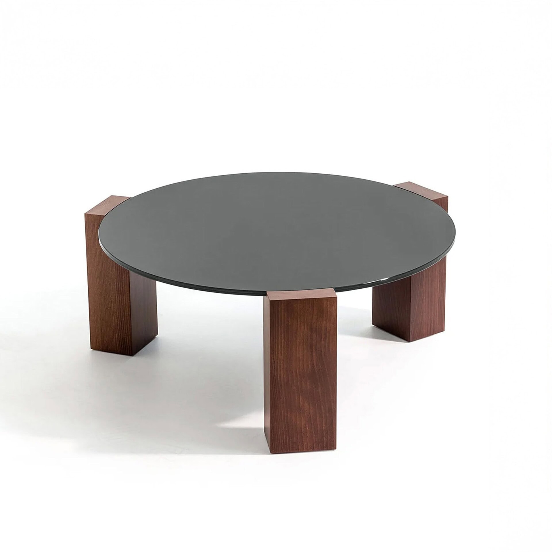 Studio product shot of the Gogan Sculptural Low Coffee Table with a round glass top and varnished ash wood base.