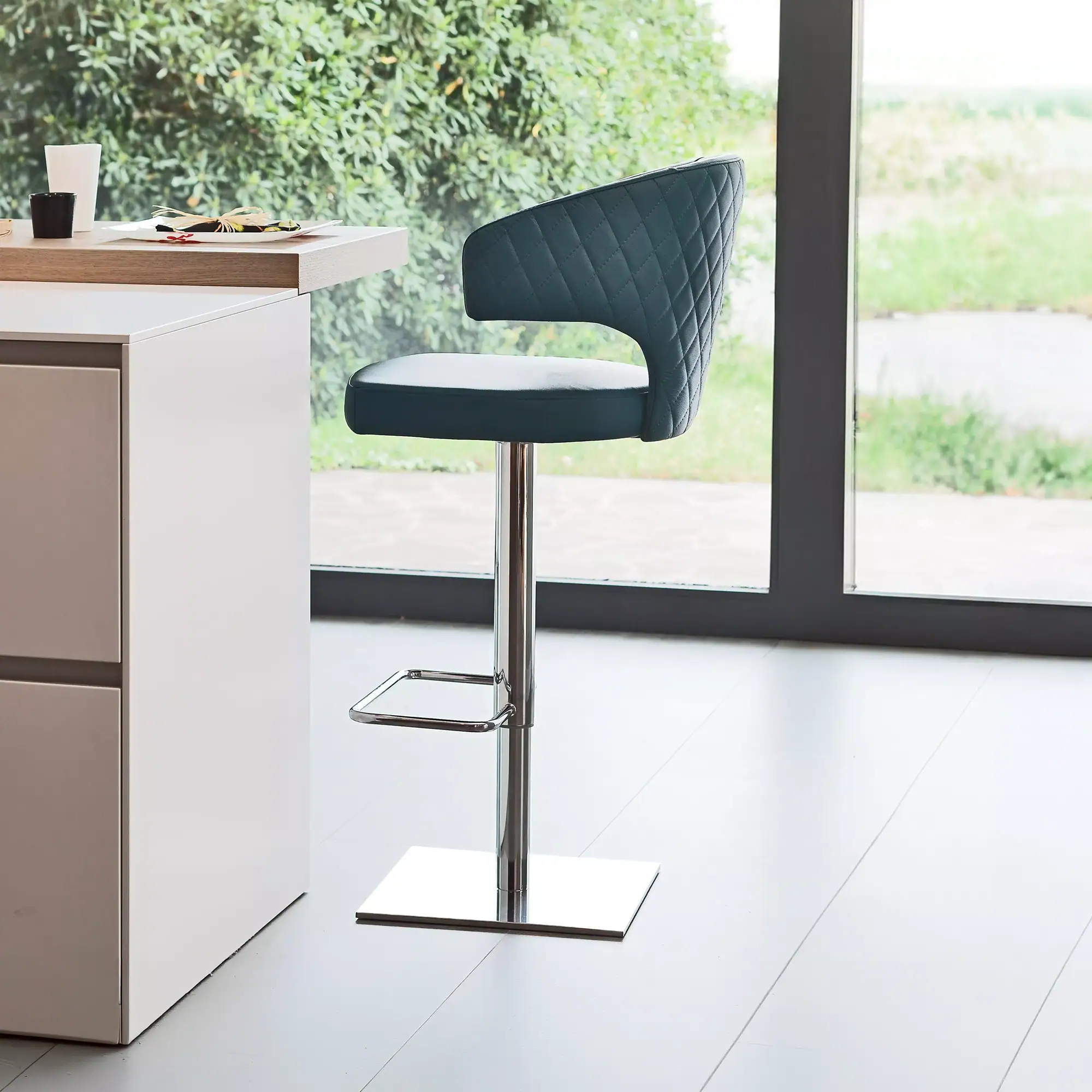 Sklar Furnishings Wing Modern swivel bar stool with quilted backrest near window.