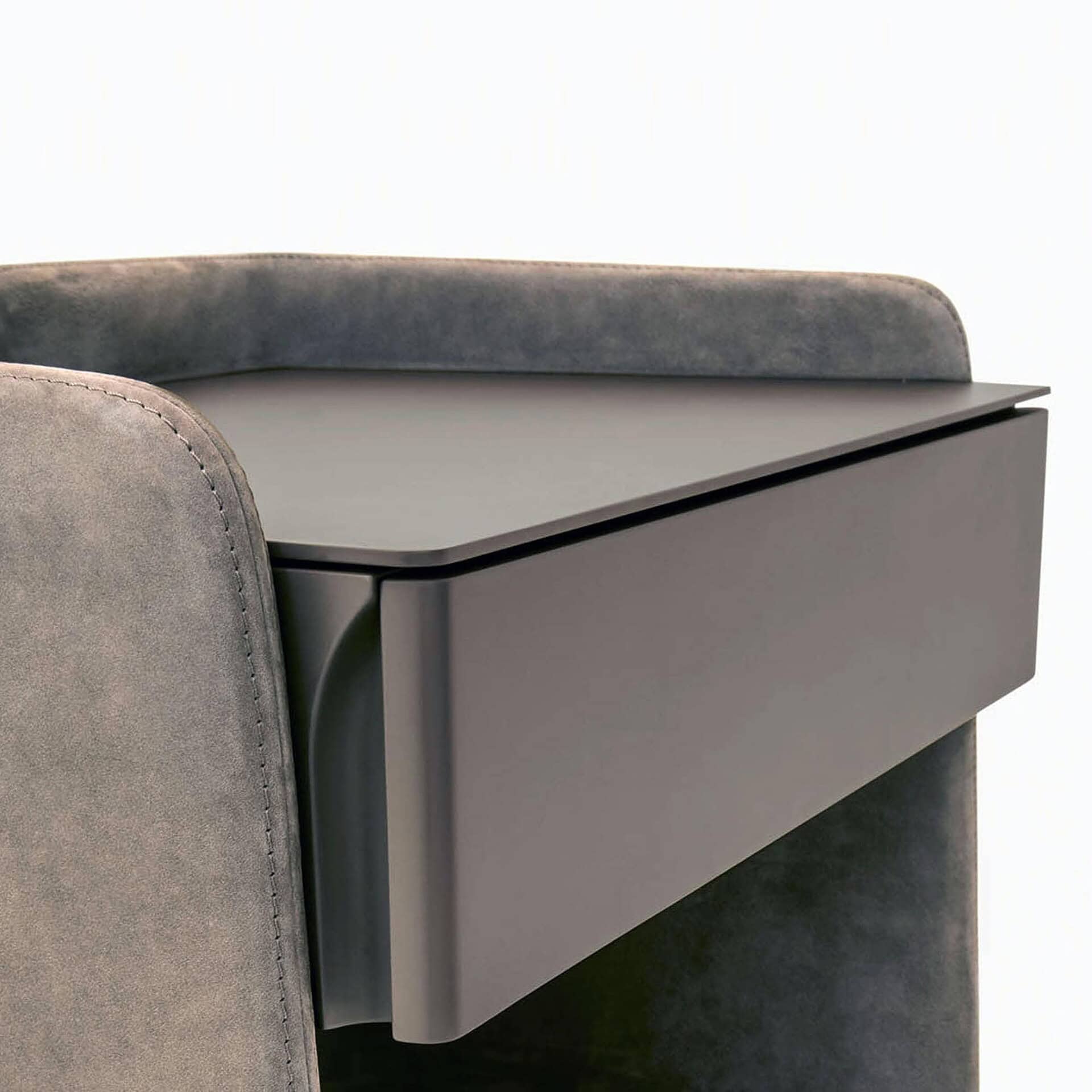Side profile of the Chloé Upholstered Nightstand showing curved fabric structure and sleek handle-free drawer design.