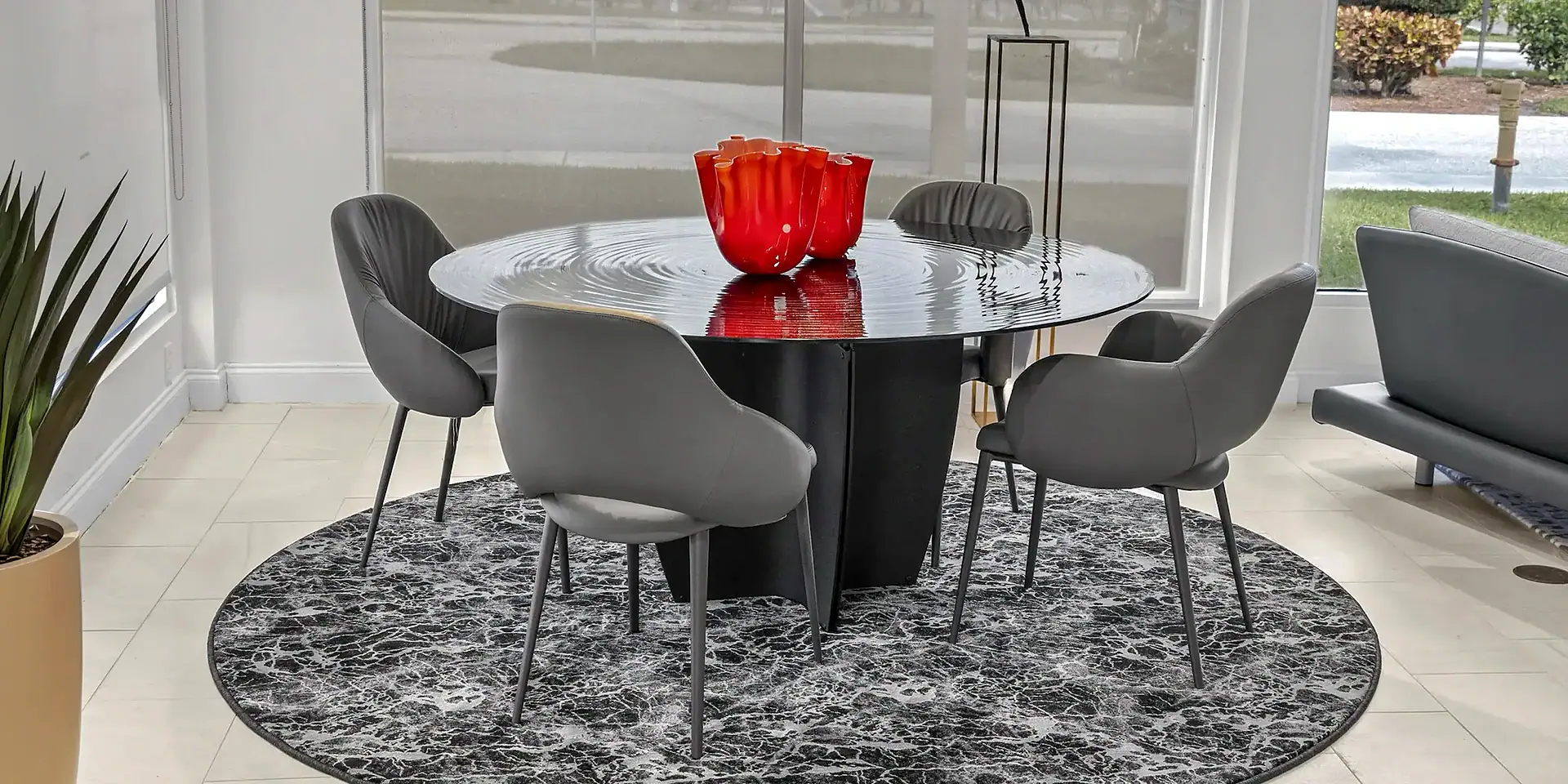 Contemporary dining room with modern black round table and stylish gray chairs, perfect for elegant gatherings.